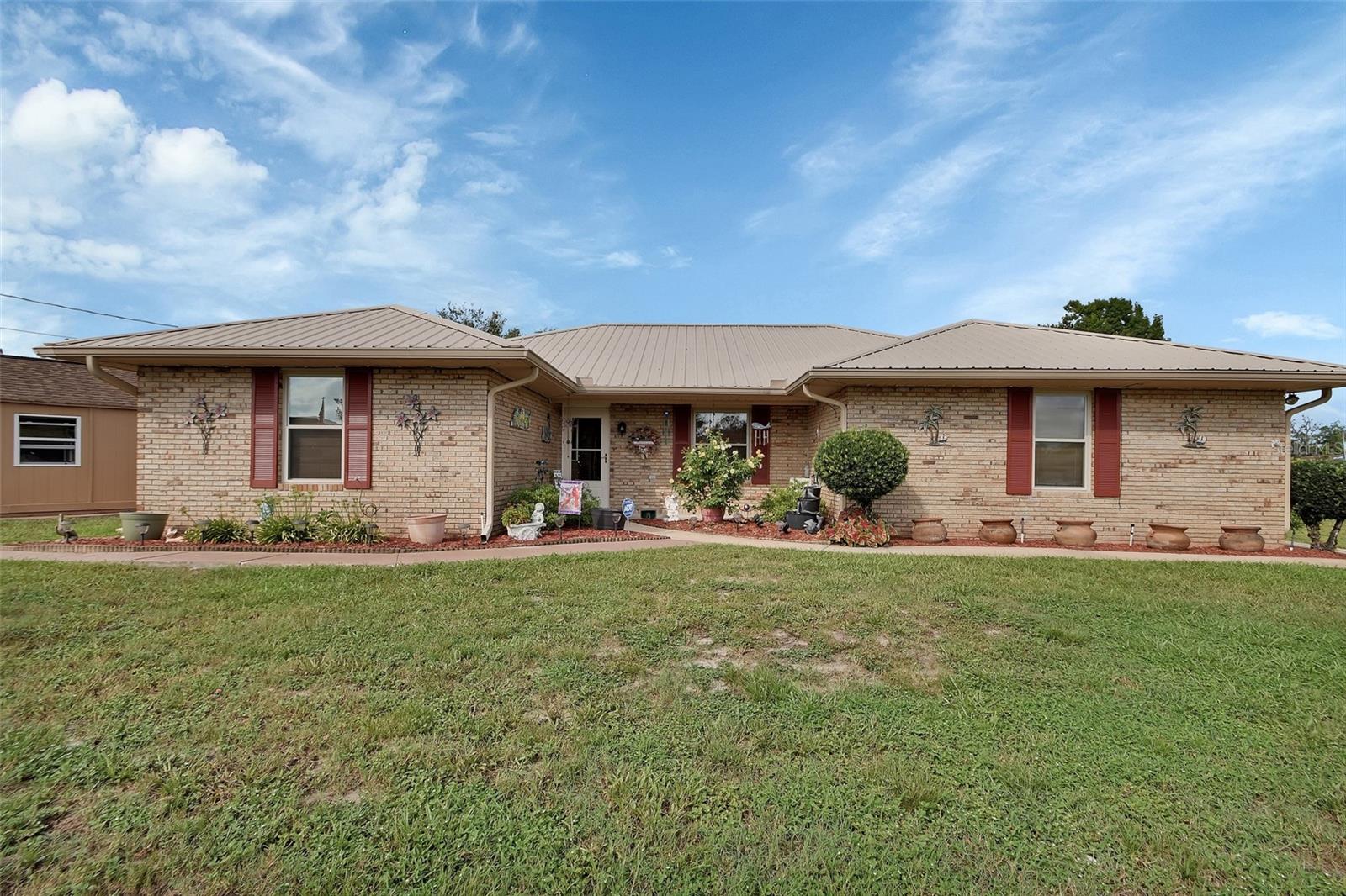 Welcome to 1875 Monticello Street in Deltona — a beautifully maintained brick home built by respected local builder Dan Moore, known for quality craftsmanship. This 3-bedroom, 2-bath pool residence offers 2,025 sq ft of heated living space, including an oversized enclosed 2-car garage with a new mini-split system. The garage can easily be converted back to its original use, if desired.
The layout flows comfortably from the tiled entry into a spacious living room, a Florida room currently used as a dining area, and an updated kitchen. The kitchen features solid wood cabinets, soft-close drawers and doors, stunning granite countertops, a center island with seating, and stainless steel appliances.
Additional upgrades include energy-efficient double-pane windows, AC new in 2021 , and a durable metal roof installed in 2015. Features also include an interior laundry room with storage and a a 12x10 workout room.
Step outside to your own backyard retreat—featuring a large 23x40 screened-in pool and a 23x13 covered lanai, ideal for entertaining or just relaxing. Two detached buildings add flexibility: a 16x20 garage/workshop that can accommodate a vehicle, and a separate 10x12 workshop.
With two driveways, no HOA, and beautifully landscaped grounds, there’s plenty of space for vehicles, tools, or toys. Conveniently located near parks, schools, shopping and I-4 access.
This home has it all—schedule your showing today!