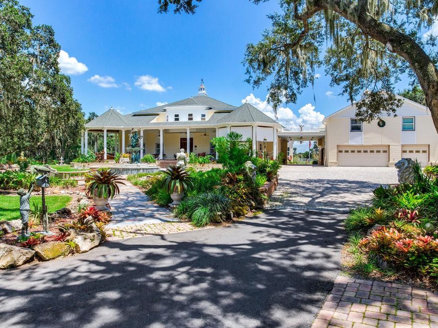 MIZELLE CREEK MULTI-FAMILY GARDEN ESTATE! This sprawling estate boasts 4 homes in addition to 3 vacant, buildable lots tucked at the end of a quiet country road in Lithia.  As you enter through the custom iron gates, you'll notice the unique details and serene atmosphere at every turn of the winding drive.  The over 10,000 square feet of living space in the manor home is the crowning jewel of the estate with its luxury and grandeur - truly a one-of-a-kind masterpiece! The potential for 7 homes on over 42 acres makes this the perfect place for a family compound or private community.  As you follow the trails you'll find two ponds - both with bridges and islands, a meandering creek, open pastures with perennial peanuts for grazing animals, a private vineyard, an expansive garage and workshop, thriving gardens with statues and motion-activated fountains, and an established shooting range.