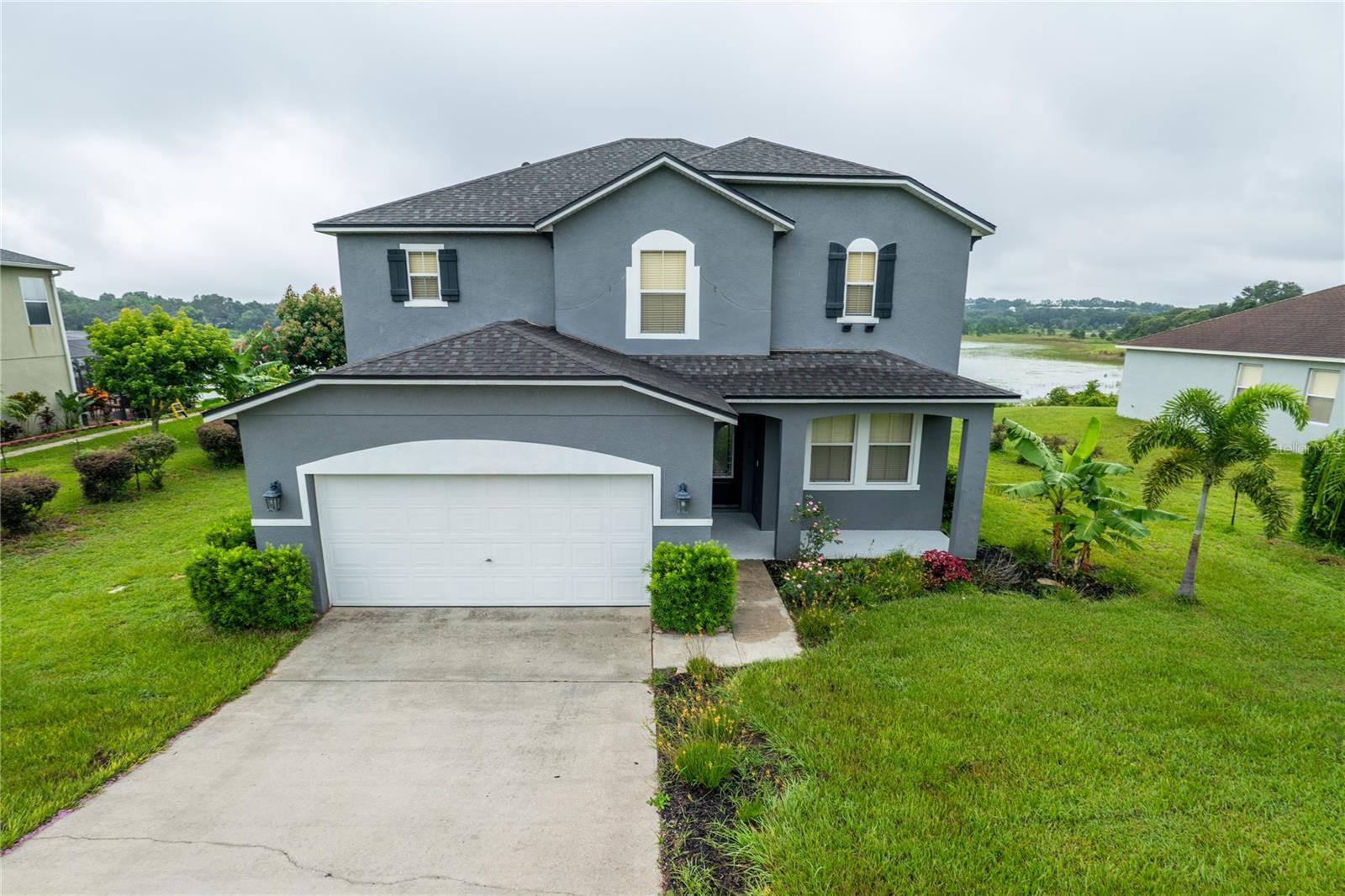 Live Lakefront in Style at Lakeview Pointe! Welcome to this stunning three-bedroom, two-and-a-half-bath lakefront home nestled on over a third of an acre in the highly sought-after Lakeview Pointe community in Clermont. Offering a blend of modern upgrades, spacious living, and breathtaking views of Jack’s Lake, this home is the perfect retreat for those seeking comfort and convenience. As you arrive, you’ll be greeted by a long private driveway and covered front patio that create a welcoming first impression. Step inside to discover a light-filled, open-concept floor plan with high ceilings and tile flooring throughout the main level. The expansive living and family room combination provides ample space for gathering, entertaining, or relaxing. The heart of the home is the gourmet kitchen, beautifully updated with shaker cabinets, quartz countertops, a spacious island with bar seating, stainless steel appliances, and a stylish modern backsplash. Enjoy meals with a view in the cozy dining area overlooking the water. Downstairs also features a convenient half bath and a large laundry room complete with cabinetry and counter space. Upstairs, a versatile loft area awaits — ideal for a playroom, home office, or media space and vinyl flooring throughout. The primary suite is a peaceful retreat with tray ceiling, a large walk-in closet, and breathtaking lake views. The en-suite bath includes his and her vanities, a soaking tub, and a glass-enclosed walk-in shower. Two additional bedrooms are generously sized, each with ceiling fans and ample closet space, and they share a full bath with a tub/shower combo. Step through the sliding glass doors to the screened-in back patio, the perfect spot for enjoying morning coffee or evening tranquility. The huge backyard leads to the water’s edge of Jack’s Lake, known for great fishing and scenic beauty. With east-facing front exposure, you’ll enjoy spectacular sunset views over the lake