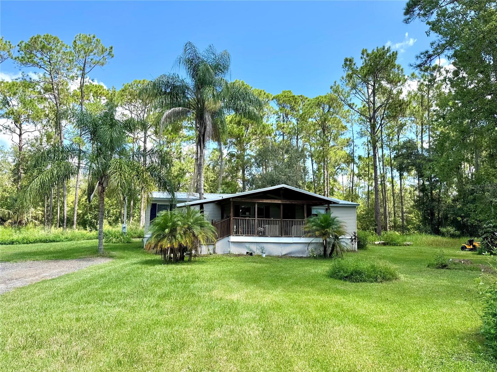 Welcome to LUXURY COUNTRY LIVING sitting on ONE full acre LEVELED & CLEAR LOT with NO HOA on a DEAD-END STREET. This FULLY RENOVATED HOME BOASTS a METAL ROOF, NEW HVAC/air-ducts, and an OVERSIZED DRIVEWAY for parking, offering the perfect blend of COMFORT & SERENITY. Enjoy relaxing in either an OPEN/EXTRA LARGE COUNTRY-STYLE FRONT PORCH or in a SCREENED-IN REAR PORCH. The interior offers: ALL WHITE INTERIOR WALLS, LIGHT GREY FLOORS, starting with a SPACIOUS LIVING ROOM, and LUXURY VINYL PLANK FLOORING all throughout the SPLIT-PLAN layout with 3 bedrooms and 2 bathrooms. The Master bedroom contains his-and-her closets, one of which is a WALK-IN closet. The second bedroom also offers a walk-in closet. The Master bathroom is spacious, featuring double sinks, a tub, and a separate shower. The BEAUTIFUL KITCHEN features ALL-WHITE CABINETS, QUARTZ COUNTERTOPS, and STAINLESS STEEL APPLIANCES. The LG WASHER & DRYER are located in a separate LAUNDRY ROOM off the kitchen. You'll appreciate the NEW WHOLE HOUSE WATER FILTRATION SYSTEM, complete with a Reverse Osmosis filter under the sink for FRESHWATER DRINKING, as well as a NEW SEPTIC system. Enjoy the benefits of your own PRIVATE ROADWAY and plenty of space for PARKING LARGE RV or TRUCKS. MATURE TROPICAL WOODLANDS embellished with beautiful Palm Trees SURROUND the property for MAXIMUM PRIVACY. The large garden comes with TWO EXTERIOR STORAGE SHEDS. Whether you have livestock, commercial vehicles, or are simply looking to enjoy the peace and quiet offered by nature, this rental property offers a unique, safe haven hard to find. This secluded retreat of a home is conveniently located at the corner of RT-17 and Ernie Caldwell Blvd, and you’re JUST 10 MINUTES DRIVE TO I-4, where you’ll find shopping centers, Disney, and the entertainment district.