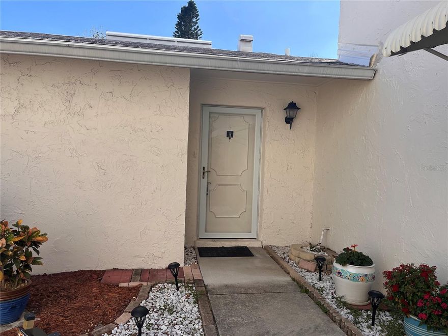 This 2 bedroom, 2 bath unit has been meticulously cared for!  There are porcelain tile floors throughout, impact-resistant windows and sliders, and custom window treatments.  The kitchen was updated with a cut-out for an open look, both bathrooms have been completely updated, one with a tub, one with a walk-in shower.  The a/c has been professionally serviced annually and functions perfectly.  Roof replaced in 2021 as well as the water heater and expansion tank.  The patio has been enclosed with white PVC basket-weave fence for esthetics and privacy.  There is a one car garage that has a storage closet.  This unit is ready for you to immediately move into and start enjoying as it has been professionally cleaned upon the Seller vacating.  West Shore Village a highly desired gated community. This community offers a number of amenities such as shuffleboard, a lovely picnic area, pickle ball/tennis courts, Pool and a clubhouse with a pool table and a lending library. The social complex hosts multiple parties and special events to enjoy all year round.  West Shore Village is a short commute from the bustling downtown and waterfront area of St Petersburg with its boutique shopping, dining, numerous museums, and many entertainment venues. Short drive to Fort DeSoto and the beautiful sands of St Petersburg Beach. Easy commute to Tampa and Tampa International Airport to the north and the iconic Skyway Bridge and Sarasota/Bradenton area to the south.  Come enjoy your slice of Paradise!!