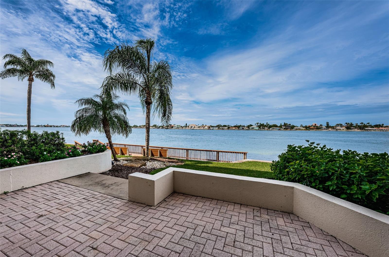 RARELY available 1st floor condo. Overlooking the intracoastal waterway, you'll enjoy watching the many boats and nature at its best with dolphin sightings right from the expansive patio of this 1st floor condo. As soon as you step through the front door, your eyes will be instantly drawn to the water view beyond. The large eat-in kitchen features ample cabinets and counterspace, perfect for casual dining and entertaining. The kitchen overlooks the spacious and comfortable dining and living rooms where sunsets and water views can be enjoyed. The generous sized primary suite with direct access to the patio features a large walk-in closet and en-suite bathroom with double vanity and garden tub. The split floorplan offers privacy with a sizable guest bedroom that is adjacent to the secondary bathroom with step-in shower. Extra include hurricane-rated sliding doors in both the living room and primary suite, in-unit laundry room with full-size washer & dryer, and assigned parking spot #205 just steps from your front door. This Club Bahia unit offers a private heated pool and spa, community room and fitness room surrounded by tropical landscaping. Whether you're seeking a full-time residence, a vacation getaway, or a strong investment opportunity, this maintenance-free, waterfront condo checks every box. Take advantage of a golf, tennis, yacht or social membership offered at Isla Del Sol Yacht & Country Club. All of this, and within minutes of the award-winning beaches of Fort Desoto State Park, and top ranked St Pete Beach. Quick access to I-275—just 15 minutes to vibrant downtown St. Petersburg's restaurants, shops, and nightlife