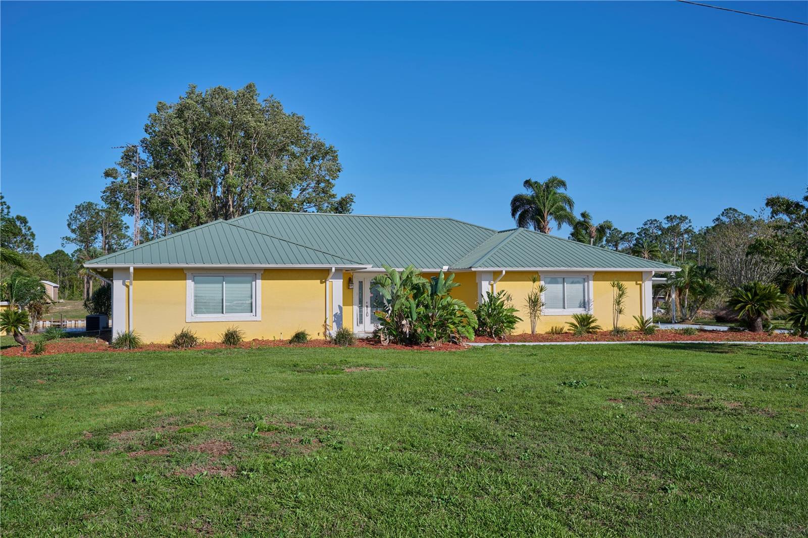 Experience the ultimate in lakefront living at 6589 Banyan Dr, a standout property in the serene Indian Lake Estates community that offers something truly rare—uninterrupted sunset views over Lake Weohyakapka right from your front yard. This beautifully maintained 2-bedroom, 2-bathroom home combines comfort, functionality, and exclusive water access, all on a peaceful canal with a large private dock and boat lift. The expansive dock isn’t just for boating—it’s perfect for al fresco dining, morning coffee, or entertaining friends while taking in the tranquil surroundings. Inside, you’ll find a bright, open layout filled with natural light, a spacious living area, and a well-appointed kitchen with modern appliances and ample counter space. A durable metal roof, lush landscaping, and a garden shed add to the home’s charm and practicality, while the two-car garage and additional two-car carport offer plenty of space for vehicles and storage. Whether you’re fishing from your backyard, kayaking the quiet canal, or relaxing with a glass of wine at sunset, this one-of-a-kind home offers a rare opportunity to enjoy waterfront living at its finest in Indian Lake Estates.