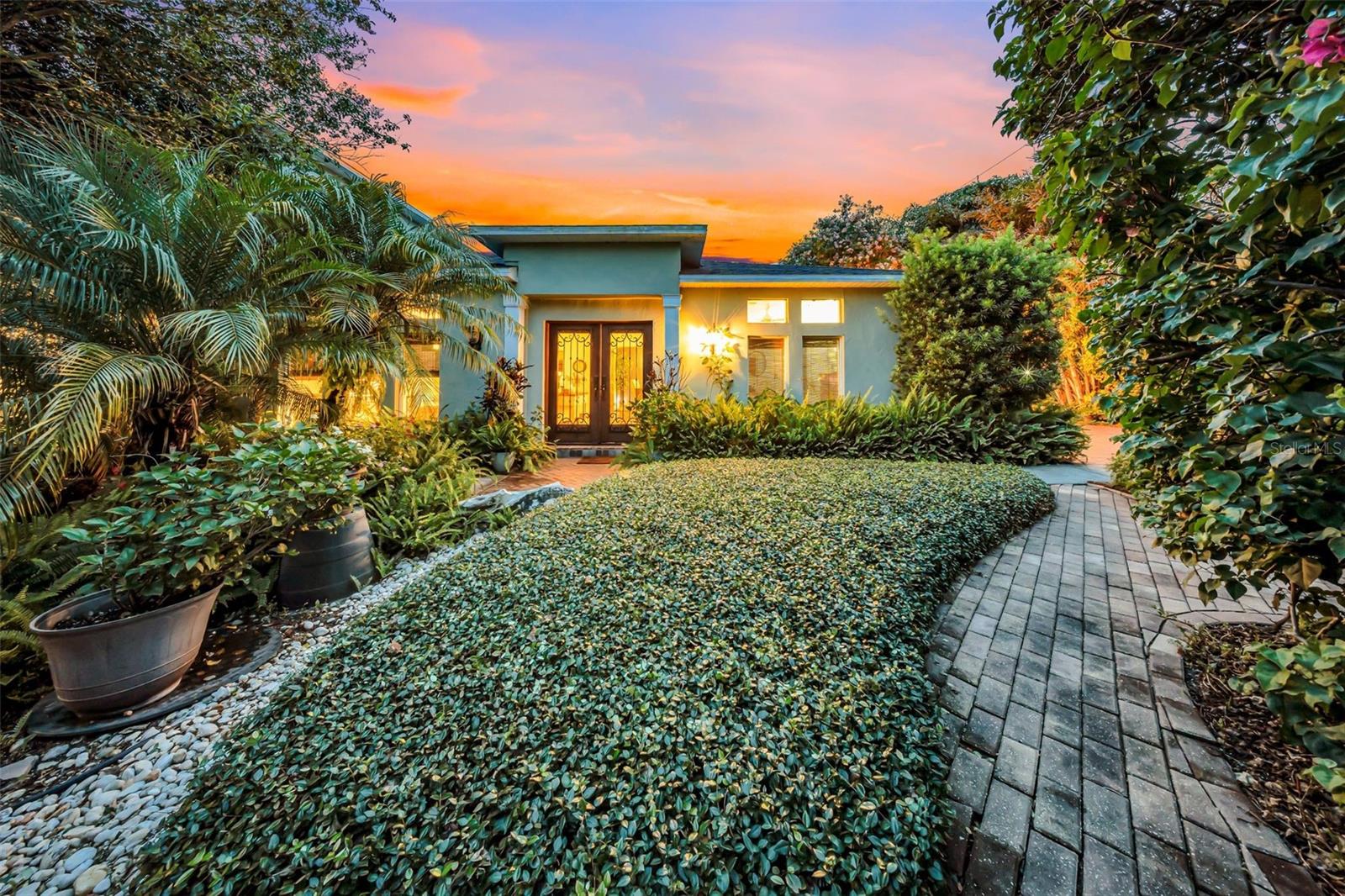 MUST SEE HOME IN SAFETY HARBOR! Welcome to your private retreat nestled on a beautifully landscaped corner lot along iconic Main Street in Safety Harbor. NO FLOOD ZONE. This charming and beautifully updated 4-bedroom, 4-bathroom residence combines timeless elegance with laid-back Florida living. You’ll enjoy 3,123 sqft under air and 3,949 total sqft including the epoxy-finished garage and covered porch, all situated on a 10,851 sqft lot—making this one of the largest homes to hit the market in this prime Safety Harbor neighborhood in the past year.
Thoughtfully updated over the last four years to capture a vibrant Key West coastal aesthetic, the home is infused with warmth, character, and charm at every turn. It features a new roof (2021), full hurricane-impact windows throughout, and soundproof front-facing windows for added peace and quiet. It’s also just a short walk to the iconic Safety Harbor Resort & Spa, the scenic Bayshore Trail, and a vibrant downtown filled with award-winning restaurants, boutiques, parks, a marina, year-round festivals, and a thriving local arts scene. One AC unit was replaced in 2022, and the second unit is from 2014.
Enter through striking mahogany double doors and be greeted by a blend of Saltillo Mexican tile and hardwood floors, arched entryways, and abundant natural light. The spacious dining room features a vaulted ceiling, setting the stage for memorable gatherings. The chef’s kitchen offers solid wood cabinetry, a natural gas cooktop, range hood, butcher block counters, stainless steel appliances, a pass-through breakfast bar to the living room, and views of the lush gardens. A tankless gas water heater ensures energy-efficient, on-demand hot water. Just off the dining room is a reading/coffee nook with built-in shelving and a spacious butler’s pantry—perfect for extra storage and entertaining flow.
Upstairs, the 813 sqft master suite offers a tranquil escape with a private balcony, a spa-inspired en-suite bathroom featuring a Bain Ultra Thermaseur jetted tub, large Jack-and-Jill walk-in closets, and a resort-like ambiance designed for relaxation.
Downstairs, the 4th bedroom serves as a private guest or in-law suite—ideal for multigenerational living or short-term rental—with hurricane-rated French doors, a private entrance, soundproofed walls, a dedicated patio, and a separate driveway for complete privacy and convenience.
Step outside into your tropical sanctuary with elevated outdoor living. An expansive brick-paver courtyard winds through mature, lush gardens, perfect for entertaining guests or enjoying a peaceful evening under the stars.
Located in one of Tampa Bay’s most beloved waterfront towns, the home is ideally positioned between Clearwater, Tampa, and St. Petersburg—just 20 minutes to Tampa International Airport, 10 minutes to St. Pete–Clearwater Airport, 10 minutes from the Courtney Campbell Causeway, and only 20 minutes to Clearwater’s award-winning beaches.
This is your chance to own a one-of-a-kind home—and one of the only truly move-in-ready properties available in this coveted location.