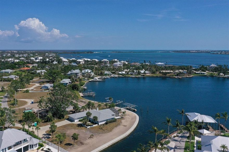 The extraordinary tip lot property offers about .8 acres, 330 feet of bay AND canal frontage and astounding water views. The classic Florida home provides a boat lift for a 23 foot boat, large vessel sailboat water dockage, is seconds to the Intracoastal Waterway, only about 1 mile to the Gulf of Mexico, and is located on a secluded tree-lined street in the Cape Haze neighborhood developed by the legendary Vanderbilt family. The spacious 1978 built house is perfect for entertaining with 2,757 sq.ft., large living and dining rooms, expansive sun porch and screened lanai. The new seawall was completed March 2023, the open kitchen was renovated and sun porch enclosed in 2001, and screened lanai added in 2009. There is plenty of land to add a swimming pool in multiple locations and a separate garage and guest suite. The long private driveway has an RV parking space and power hookup. The home is just a short boat ride or drive to historic Boca Grande, multiple marinas, and countless island destinations. Close to numerous golf courses, private Coral Creek Jetport, shopping, and miles of tranquil sandy beaches.