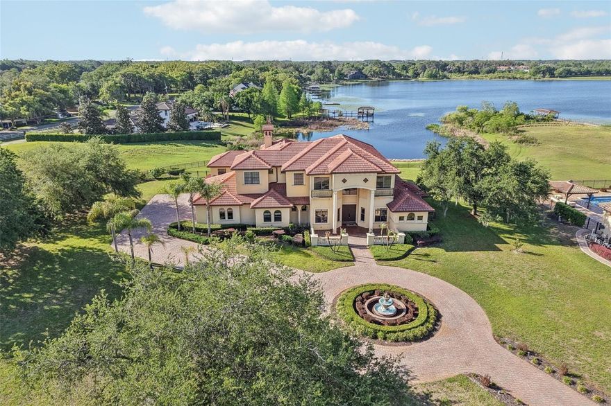 Nestled within one of **Windermere**’s most exclusive communities, this extraordinary custom-built lakefront estate with an almost 2 acres lot offers an elegant lifestyle defined by privacy, prestige, and breathtaking nightly views of the **Walt Disney World** fireworks. With nearly 6,000 square feet, six bedrooms, and six and a half baths, this residence is the pinnacle of refined Central Florida living.

A long, winding driveway welcomes you, framed by mature trees and sweeping lawns. Tucked away on a quiet cul-de-sac within a 24-hour guard-gated neighborhood with a manned guard station, the property offers both grandeur and seclusion — a rare combination in today’s luxury market.

Thoughtfully designed to maximize natural light and panoramic water views, the home features soaring ceilings, expansive picture windows, and seamless indoor-outdoor flow. The grand foyer opens to a spectacular living room anchored by tranquil lake vistas. The chef’s kitchen is appointed with custom cabinetry, high-end appliances, and an oversized island, effortlessly connecting to spacious dining and living areas — ideal for both intimate evenings and large-scale entertaining.

The primary suite, located on the main level, is a private sanctuary with serene lake views and direct access to the outdoor living areas. The spa-inspired bath offers a soaking tub, dual vanities, walk-in shower, and generous closet space. Four additional bedrooms of which two of them include their own en-suite bath, ensuring comfort and privacy for family and guests.

A detached in-law suite with private entrance, living area, bedroom, and bath provides exceptional flexibility for multigenerational living, long-term guests, or a private executive office.

Step outside to your own outdoor oasis. The resort-style pool overlooks the lake, creating a stunning backdrop for entertaining or quiet relaxation. A charming pool house complete with a Murphy bed offers additional guest accommodations and enhances the estate’s resort-like ambiance. At the water’s edge, a private dock provides access to a private ski lake — perfect for boating, skiing, paddleboarding, or sunset cruises.

As evening falls, the magic begins. From your backyard, dock, or expansive windows, enjoy nightly fireworks illuminating the sky above Disney — a spectacular private show reflected across the water. With nearly two acres of lakefront land, six bedrooms, six and a half baths, a detached suite, pool house, long private driveway, and location within one of Windermere’s most prestigious guard-gated communities, 12720 Jacob Grace Ct is more than a home — it is a destination, a sanctuary, and a stage for life’s most extraordinary moments.