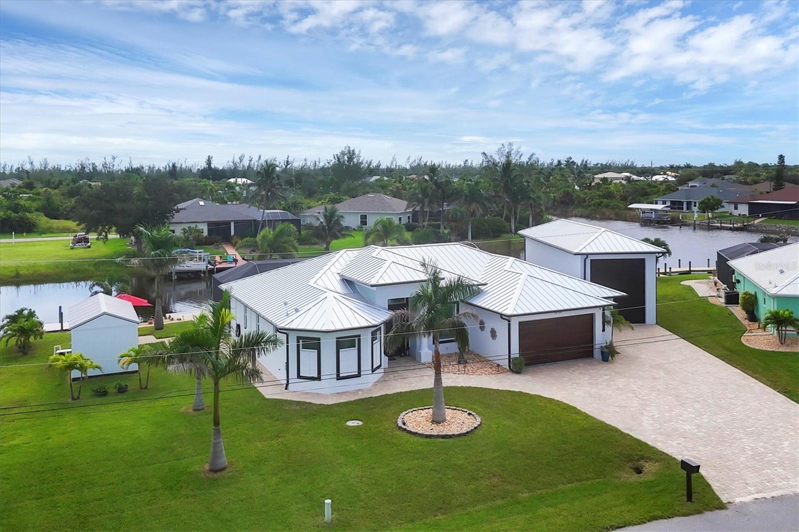 Welcome to coastal perfection in this exceptional custom-built waterfront home, nestled in the coveted South Gulf Cove community. This magnificent residence sits gracefully on a rare double lot, boasting an impressive 213 feet of waterfront, complete with two private docks, a 10,000 lb boat lift, and easy access to open water — your gateway to Boca Grande, Gulf beaches, and world-class fishing. Step into elegance through custom hurricane-rated double doors, where a grand open floor plan unfolds before you. Designed for both everyday living and sophisticated entertaining, this home is filled with natural light, highlighted by zero-degree corner sliders that completely disappear — seamlessly blending indoor and outdoor living. Imagine sunset cocktails on the expansive lanai, dips in the heated saltwater pool, and gatherings under the stars. The pavered driveway wraps gracefully around the home all the way to the docks, creating a stunning entrance and effortless functionality. For the culinary enthusiast, the gourmet kitchen is a dream: a center island, upscale stainless steel appliances, rich granite countertops, and cabinetry that’s as beautiful as it is functional. The great room features soaring 14-foot tray ceilings — adding to the drama and spaciousness of this thoughtfully designed floor plan. The master suite is your private retreat, with hurricane-rated sliders that open to the pool and water views. Indulge in a spa-like en suite bathroom with dual vanities and generous walk-in closets. Two additional guest bedrooms, positioned on the opposite wing of the home, offer peaceful privacy for family or visitors. Need space for the toys? You'll love the 15x48 RV garage, built to accommodate your biggest adventures — boats, campers, or collector vehicles — with plenty of room to spare. Top it all off with peace-of-mind upgrades: hurricane-impact windows and doors, reinforced garage doors, and a brand new roof (2025). Every detail of this home has been meticulously crafted for luxury, safety, and comfort. Paradise is calling. Schedule your private tour of this one-of-a-kind waterfront estate and experience what it feels like to live the Florida dream — in true million-dollar style.