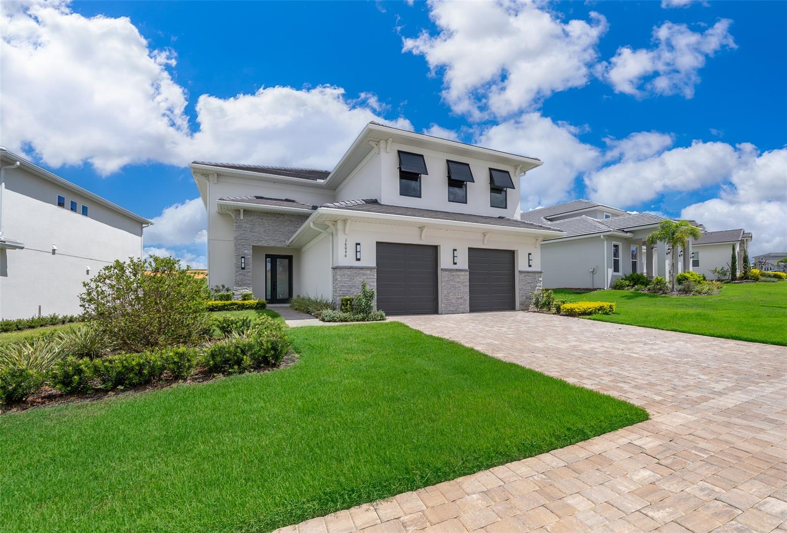 An exceptional luxury residence nestled in the exclusive gated golf community of Bella Collina in Montverde, FL. This custom-built, contemporary 4-bedroom, 4.5-bath home showcases striking architectural design and modern finishes throughout.
Step inside to soaring ceilings and expansive windows that flood the open-concept living spaces with natural light. The main level boasts a sleek designer kitchen featuring shaker cabinetry, quartz countertops, stainless steel appliances, double ovens, a gas cooktop, an oversized island with seating, and a built-in wine cooler. The spacious dining area is enhanced by a dazzling crystal chandelier and opens seamlessly to the great room—perfect for entertaining or relaxing in style.
The primary suite offers serene views, plush carpeting, and a spa-like ensuite bath, complete with double vanities, a frameless glass shower, and a generous walk-in closet. Three additional bedrooms—one located on the main floor with private access and two upstairs—are thoughtfully designed with ample closet space and share beautifully appointed bathrooms.
Enjoy indoor-outdoor living with sliding glass doors leading to a covered lanai and lush backyard with sweeping views of the rolling hills and golf course beyond. Whether hosting al fresco dinners or relaxing in the fresh Florida breeze, this outdoor space is the ultimate retreat.
Additional highlights include: Motorized window treatments; Textured, modern accent walls; 2-car garage with stone accents; Elegant porcelain tile floors throughout the main living areas; Laundry room with storage and utility sink; Upgraded lighting fixtures; Situated on a premium lot with no rear neighbors.
As a resident of Bella Collina, you’ll have access to world-class amenities, including a Sir Nick Faldo–designed championship golf course, resort-style pool, full-service spa, Har-Tru tennis courts, pickleball courts, fitness center with complimentary classes, basketball courts, playground, dog park, boat ramp and fine dining—all within the security and serenity of a 24-hour guard-gated community. You'll also enjoy a vibrant year-round calendar of culinary, sports and social events, offering an array of activities for every member of your family.