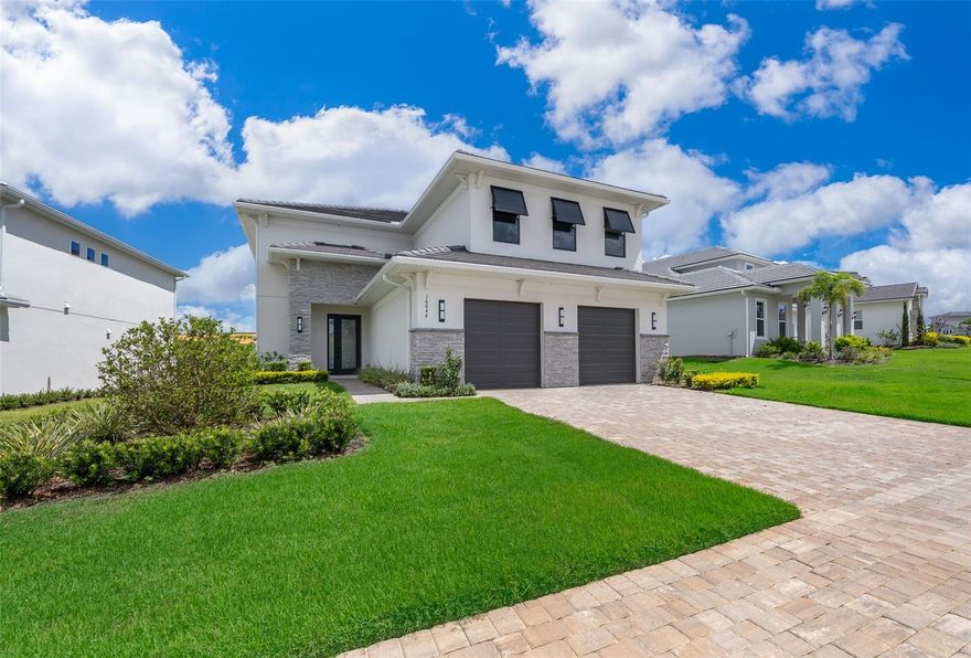 An exceptional luxury residence nestled in the exclusive gated golf community of Bella Collina in Montverde, FL. This custom-built, contemporary 4-bedroom, 4.5-bath home showcases striking architectural design and modern finishes throughout.

Step inside to soaring ceilings and expansive windows that flood the open-concept living spaces with natural light. The main level boasts a sleek designer kitchen featuring shaker cabinetry, quartz countertops, stainless steel appliances, double ovens, a gas cooktop, an oversized island with seating, and a built-in wine cooler. The spacious dining area is enhanced by a dazzling crystal chandelier and opens seamlessly to the great room—perfect for entertaining or relaxing in style.

The primary suite offers serene views, plush carpeting, and a spa-like ensuite bath, complete with double vanities, a frameless glass shower, and a generous walk-in closet. Three additional bedrooms—one located on the main floor with private access and two upstairs—are thoughtfully designed with ample closet space and share beautifully appointed bathrooms.

Enjoy indoor-outdoor living with sliding glass doors leading to a covered lanai and lush backyard with sweeping views of the rolling hills and golf course beyond. Whether hosting al fresco dinners or relaxing in the fresh Florida breeze, this outdoor space is the ultimate retreat.

Additional highlights include: Motorized window treatments; Textured, modern accent walls; 2-car garage with stone accents; Elegant porcelain tile floors throughout the main living areas; Laundry room with storage and utility sink; Upgraded lighting fixtures; Situated on a premium lot with no rear neighbors.

As a resident of Bella Collina, you’ll have access to world-class amenities, including a Sir Nick Faldo–designed championship golf course, resort-style pool, full-service spa, Har-Tru tennis courts, pickleball courts, fitness center with complimentary classes, basketball courts, playground, dog park, boat ramp and fine dining—all within the security and serenity of a 24-hour guard-gated community. You'll also enjoy a vibrant year-round calendar of culinary, sports  and social events, offering an array of activities for every member of your family.