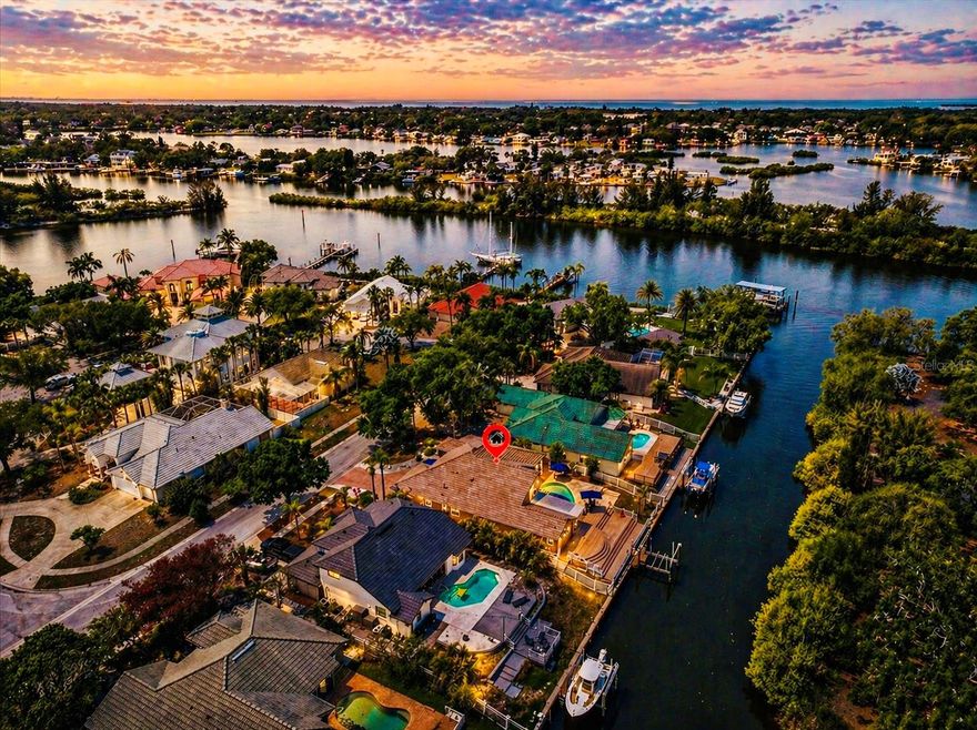 WATERFRONT BOATER’S PARADISE IN TARPON SPRINGS! A rare opportunity to experience true waterfront living in the exclusive enclave of Anclote Isles. Perfectly positioned on a private stretch of canal, this residence delivers a dream come true for serious boaters: a private dock with a 12,000 lb Hi-Tide boat lift, deep water flow through canal, no bridges, and direct Gulf access. The yard is fully fenced in and the lush tropical vegetation across the canal eliminates the direct sightlines typical of canal-front homes, creating a level of privacy that is nearly impossible to find.
Built with quality construction by Pioneer Homes, this meticulously maintained residence is designed for those who appreciate refined outdoor living. The outdoor experience is nothing short of spectacular, enhanced by more than $100,000 in upgrades. A sparkling heated pool with travertine decking anchors the space, complemented by a magnificent outdoor kitchen featuring a large natural gas grill and refrigerator. A striking two-way fireplace adds warmth and ambiance, creating the perfect setting for entertaining or quiet waterfront evenings with private sunset views. Dolphins – and even manatees – regularly glide by, adding yet another layer of magic to this one-of-a-kind waterfront retreat. 
Inside, the home offers 3 bedrooms, 3 full bathrooms, and a 2-car garage, with soaring ceilings, quality craftsmanship, and undeniable pride of ownership throughout. The living spaces are both inviting and refined, highlighted by beautiful plantation shutters and a seamless connection to the outdoor areas. 
No expense has been spared, with over $100,000 in additional major mechanical upgrades completed within the past few years, delivering both luxury and peace of mind. These include a new tile roof with double underlayment (2024), a top-of-the-line HVAC system (2026), a tankless water heater (2025), and fresh interior and exterior paint (2025). Most windows were replaced in 2022 with hurricane-impact glass, while remaining openings are protected by storm shutters, along with a hurricane-impact garage door.
Located in Flood Zone X, flood insurance is not required on this property, but the owner maintains a voluntary flood policy that may be transferred with an annual premium of only $1,084. The home has not experienced any water intrusion in past storms or hurricanes – an increasingly valuable advantage for waterfront properties.
Centrally located, but tucked away in a tranquil island community with only 19 homes, this property is within minutes from the Pinellas Trail, the world-famous Tarpon Springs Sponge Docks, Fred Howard Park, and Sunset Beach, offering the perfect balance of privacy and convenience.
Ready to make this dream yours? Your next chapter starts here – and it’s going to be spectacular!