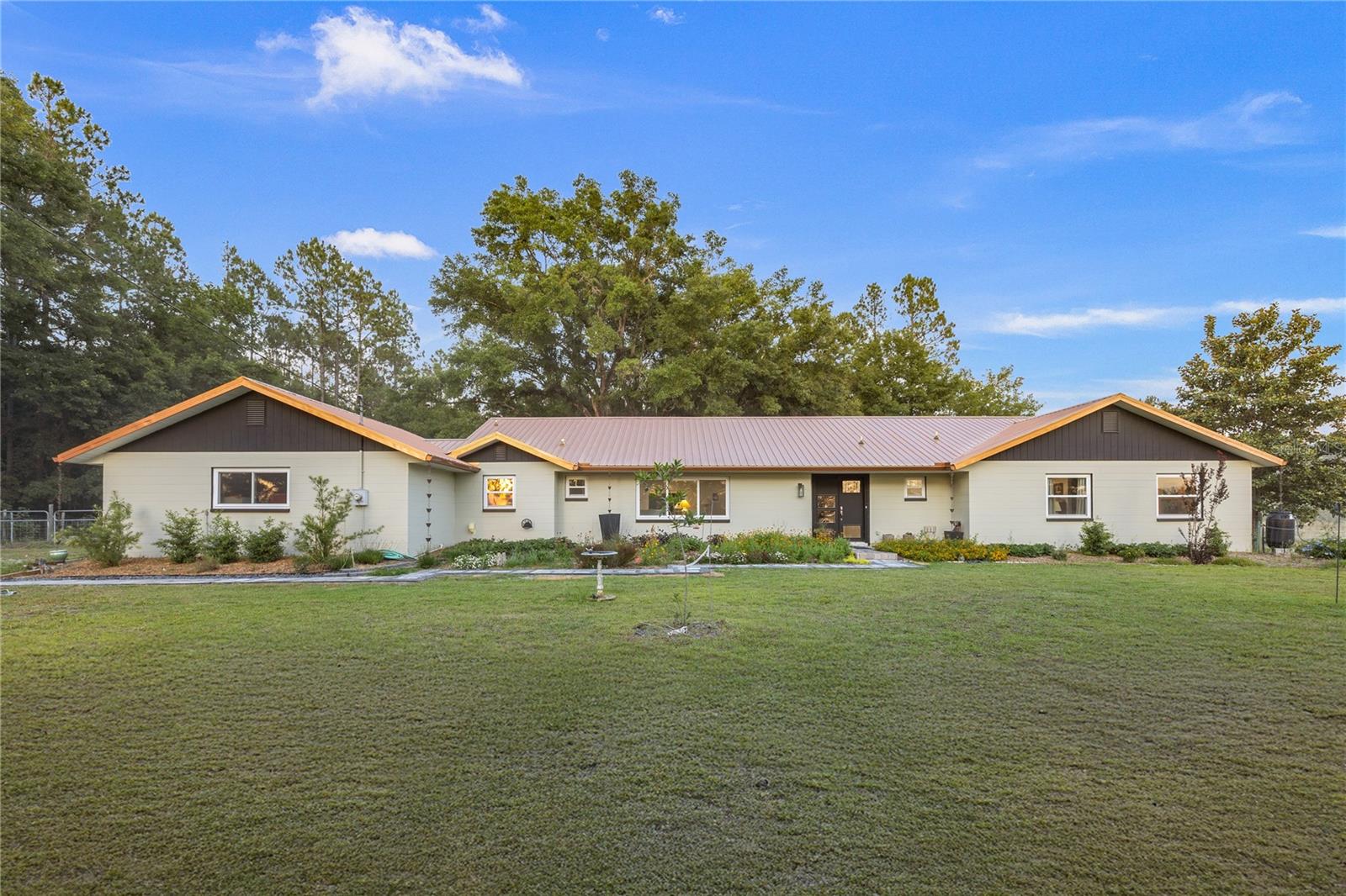 One or more photo(s) has been virtually staged. One or more photo(s) has been virtually staged. Welcome to your dream retreat! Come home to the tranquility of your dream retreat! This beautiful 4-bedroom, 2.5-bath home has been lovingly remodel starting in 2022. It sits on a spacious and serene lot, where modern updates meet country living. Inside, you'll find a bright and open floor plan with Armstrong Luxury Vinyl Plank flooring, a stunning chef's kitchen created in 2024, featuring an oversized island, sleek stainless-steel appliances including a double oven, and elegant Dekton stone countertops. This kitchen is perfect for entertaining, while island seating creates a family hub for everyday life.
The expansive living areas are filled with natural light, while each bedroom offers a peaceful escape. The primary suite features French doors to the backyard, ample space for a sitting area, and an ensuite bath with modern fixtures and dual vanities installed in 2025. Additional bedrooms offer flexibility for guests, a home gym, or a home office . The attached 2-car garage adds both functionality and convenience. Store your boat, utility trailer, AND camper inside your fenced back yard, and plug the camper into its 30 Amp outlet when needed.
Step outside to take in the tranquil setting and peaceful sounds, and enjoy breathtaking sunsets over the neighboring watermelon patch ; feel your blood pressure drop as you take in a view that feels like pure countryside charm. detached outbuilding perfect for storage, hobbies, or workshop use.
With a NEW metal roof in 2022 energy-efficient doors and windows installed in 2022, and thoughtfully landscaped grounds, this move-in ready home offers the perfect blend of modern living and rural serenity - all within easy reach of town. Need feed for that goat? Circle H feed store is 2 miles away. Need food for the humans? Newberry's beautiful new Publix is 7 minutes away. Your family and your guests will love the amenities and tranquility of your new home..