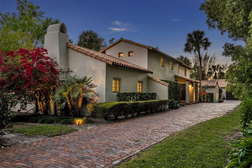 Nestled on a sprawling 0.89-acre estate, this luxurious home offers the perfect balance of privacy and convenience, just moments from the vibrant downtown Winter Park. A rare gem, this 1935 James Gamble Rogers masterpiece blends Old World charm with European influences, creating an inviting, character-rich ambiance. The main home features 3 bedrooms, 2 1/2 bathrooms, and 3,908 square feet of elegant living space, complemented by a 1-bedroom, 1-bathroom guest cottage, adding 406 square feet, for a total of 4,314 square feet. Accessed via a long, secluded driveway, this estate seamlessly blends indoor and outdoor living with lush gardens, expansive courtyards, and tranquil patios. Inside, arched doorways, reclaimed doors, and rounded stucco walls evoke a Santa Barbara Mediterranean feel. The kitchen is outfitted with stainless steel appliances, granite countertops, and a butler’s pantry—ideal for entertaining. The formal dining room opens to a living room with a curved barrel ceiling, a fireplace, and French doors leading to a garden patio. A sunlit sunroom offers panoramic garden and pool views, perfect for relaxation. The expansive downstairs owner's suite features vaulted ceilings, French doors to the patio, a cozy fireplace, and a lavish marble bath with a Jacuzzi tub, double sinks, and a dressing area with custom cabinetry and two large walk-in closets. Upstairs, two bedrooms share a beautifully renovated marble bath. The detached 2-car garage is adjacent to the laundry room, while the guest house offers a studio layout with terra-cotta floors, a kitchenette, a full bath, and French doors overlooking the pool. The backyard is an oasis of tranquility with a stunning resort-style pool, an expansive patio, and lush landscaping, providing ultimate privacy. This home offers the best of both worlds: a rare opportunity to own a piece of Winter Park history, yet lovingly maintained with modern updates and conveniences throughout.