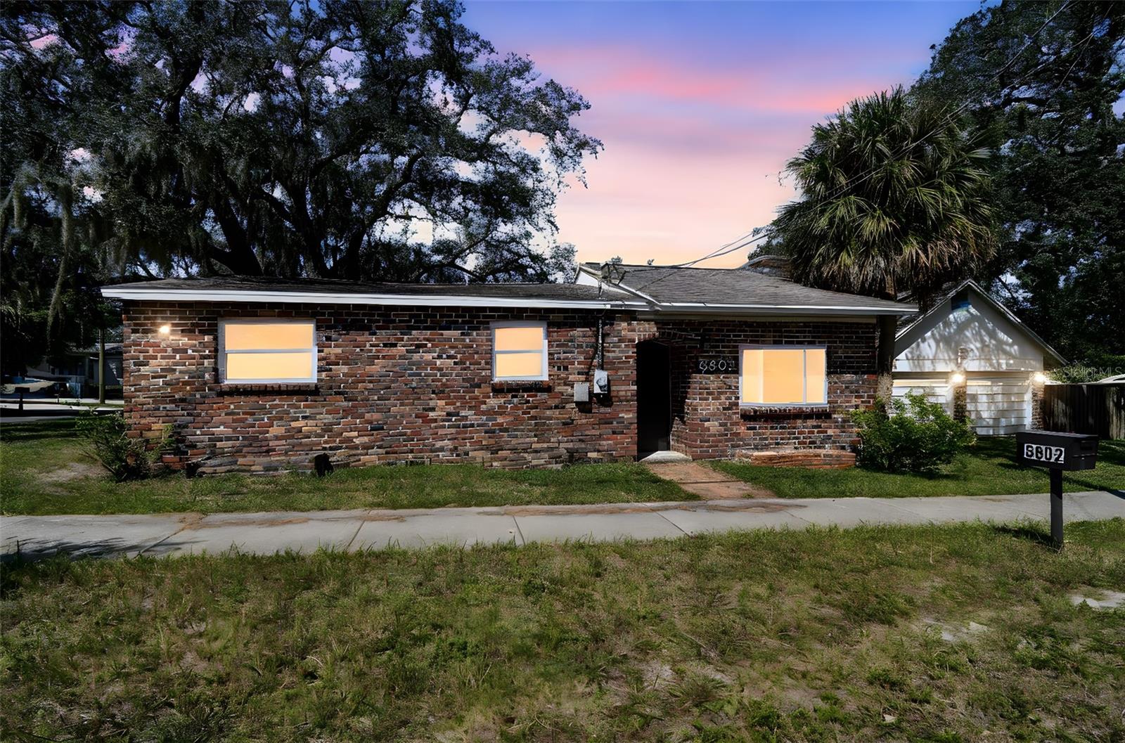 Don't pass up on the opportunity to own this beautifully unique home on a double lot in the heart of North Tampa! Located just 0.5 mile from Rowlett Park, 1.5 miles from Busch Gardens, 2.5 miles from the University of South Florida, and 7 miles from downtown Tampa - the possibilities with this property are HUGE at an affordable price. The home sits on a double lot - which is believed to be able to be split while keeping the existing home (buyer is to verify with the city). The property consists of the main home, large carport, and two car garage - complete with its own metered electric and water hookups - that could be easily renovated into an in-law suite. The home itself was constructed using bricks recycled from Tampa's cobblestone streets and has only had two owners. The family room is STUNNING and very unique with its HUGE fireplace and walls made with stone. Up a few steps from the family room - you will find the eat-in-kitchen that has been beautifully renovated with hickory cabinets and stainless appliances. The shared bath sits conveniently just outside both bedrooms. The master bedroom is large enough that a second bath could be easily added within the existing space. Step outside the kitchen area and you will exit to the covered carport which leads to the large backyard - where the possibilities are endless. This home has been lovingly upgraded over the years - some of the many upgrades include - within the last five years - New HVAC, new interior paint, electric updated, sewage line replacement, and bathroom update. Within the past ten years - the roof was replaced, new insulation, new flooring, and all windows replaced with double pane windows. This home presents a great opportunity for both investment purposes and to own a beautiful and unique home on a large lot in an awesome Central location.