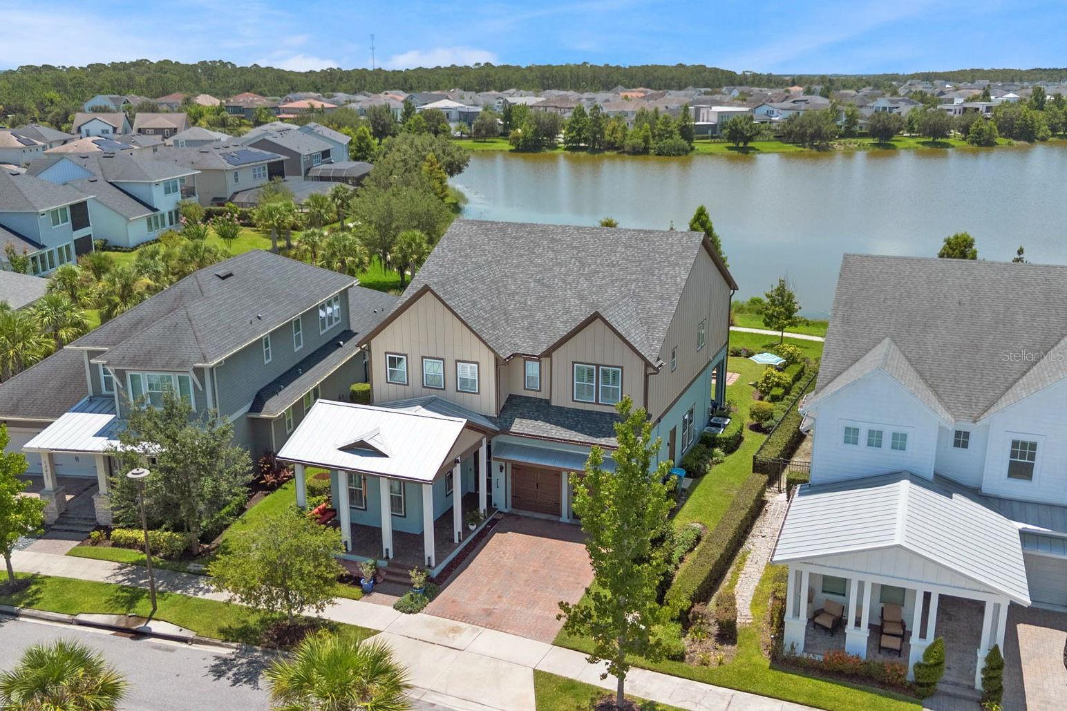 Imagine enjoying serene water views, sipping coffee on your rear lanai as the morning sun dances across the lake. Every day can start this way at 13035 Stoddart Avenue—a home designed for both grand entertaining and quiet moments. Positioned on a rare, oversized .20-acre waterfront lot in Lake Nona’s Laureate Park, this executive-style home is a sanctuary where timeless craftsman design meets modern luxury. Step through the front door and be greeted by soaring 12-foot ceilings, wood-look tile plank floors, and an abundance of natural light that fills every corner. Plantation shutters frame the front and side windows, while the windows at the rear of the home have electric blinds that open to stunning water vistas. An open-concept kitchen and family room invite connection and conversation. The single slab quartzite island takes center stage in the chef’s kitchen, complete with stainless steel appliances, double ovens, induction cooktop, Bosch dishwasher, butler’s pantry, and a separate walk-in pantry with custom storage. Thoughtful details like upgraded lighting and glass-front cabinetry elevate the space, while a seamless flow to the lanai creates effortless indoor-outdoor living. The rear covered patio with retractable screens becomes your private retreat—either open to the sunshine or screened living space when desired at the touch of a button. Enjoy evenings by the firepit, enhanced by upgraded outdoor lighting and a built-in sound system. The expansive backyard offers plenty of room for a pool, making it the perfect setting for your Florida dream lifestyle. Upstairs, a sprawling loft with electric blackout shades provides a versatile space for movie nights, a game room, or a home gym. Newly installed luxury vinyl plank flooring adds style and durability throughout the second floor. The owner’s suite has breathtaking water views, electric retractable blinds, and a spa-inspired ensuite bath featuring dual vanities, a rain shower with bench, and walk-in California Closet. Three additional upstairs bedrooms include spacious closets and beautifully updated bathrooms, while a convenient laundry room with sink and granite countertop completes the 2nd floor. This home has been meticulously upgraded with every detail considered, including a brand-new roof (2025), smart home features including Google Nest thermostats, Wi-Fi ready garage door openers, wired HD cameras, and a video doorbell. The garage offers epoxy floors, loft-style storage racks, and two EV charging stations (one inside and one outdoors). Additional characteristics of this home include a 1st-floor guest bedroom with ensuite bath, a 1st-floor home office or bonus room with access to the garage, drop zone with custom cabinetry, new upstairs HVAC system (2024), UV sterilization lights in both air handlers, surround sound wiring in the family room and loft, LED ceiling lights, upgraded fans and lighting fixtures, fresh interior and exterior paint. Laureate Park residents enjoy resort-style amenities including pools, a fitness center, community gardens, playgrounds, dog parks, and miles of trails. Top-rated schools, Medical City, Orlando International Airport, USTA, and Canvas Restaurant are all minutes away. The HOA includes basic cable, high-speed internet, and access to all community amenities. This is more than a home—it’s a lifestyle. Take advantage of this opportunity to own one of Laureate Park’s finest homes on a rare water lot by scheduling your private tour today!