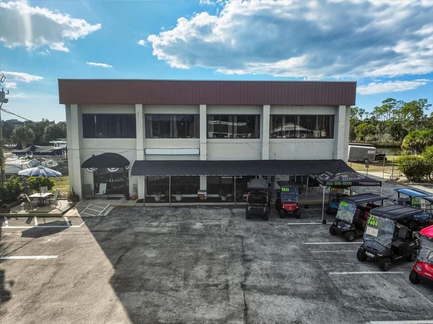 Exceptional waterfront commercial opportunity in Hernando Beach, Florida. This 6,040± square foot multi-use commercial building is situated on approximately 1.75 acres of prime waterfront land with unobstructed Gulf views. Located on a high-visibility main roadway, the property benefits from consistent daily traffic and strong year-round appeal to locals, tourists, and boaters. The property is positioned along a well-traveled waterway where boaters from Hernando Beach South and Middle must pass in order to access the community boat lift, creating steady marine traffic and visibility from the water. This unique positioning offers strong potential for marine-related exposure and future income opportunities. The improvements include a flexible layout consisting of office space, warehouse areas, and a former restaurant build-out, along with upper-level living quarters. The property also features fenced and camera-monitored RV and boat storage areas that generate income, as well as tenant space currently occupied by a golf cart sales and rental operator. The property was previously operated as a waterfront restaurant with four upstairs office suites, offering a variety of repositioning or redevelopment options. Surrounded by marinas, residential neighborhoods, and established coastal attractions, the property enjoys a strategic location with convenient access to US-19, Spring Hill, Weeki Wachee, and the greater Tampa Bay area. The waterfront setting and high marine traffic make this property particularly well-suited for marine-oriented businesses, hospitality concepts, mixed-use development, or multi-tenant commercial use. This offering presents a rare opportunity to acquire a versatile waterfront commercial asset with existing income, strong visibility, and significant long-term upside in one of Florida's most desirable coastal markets.