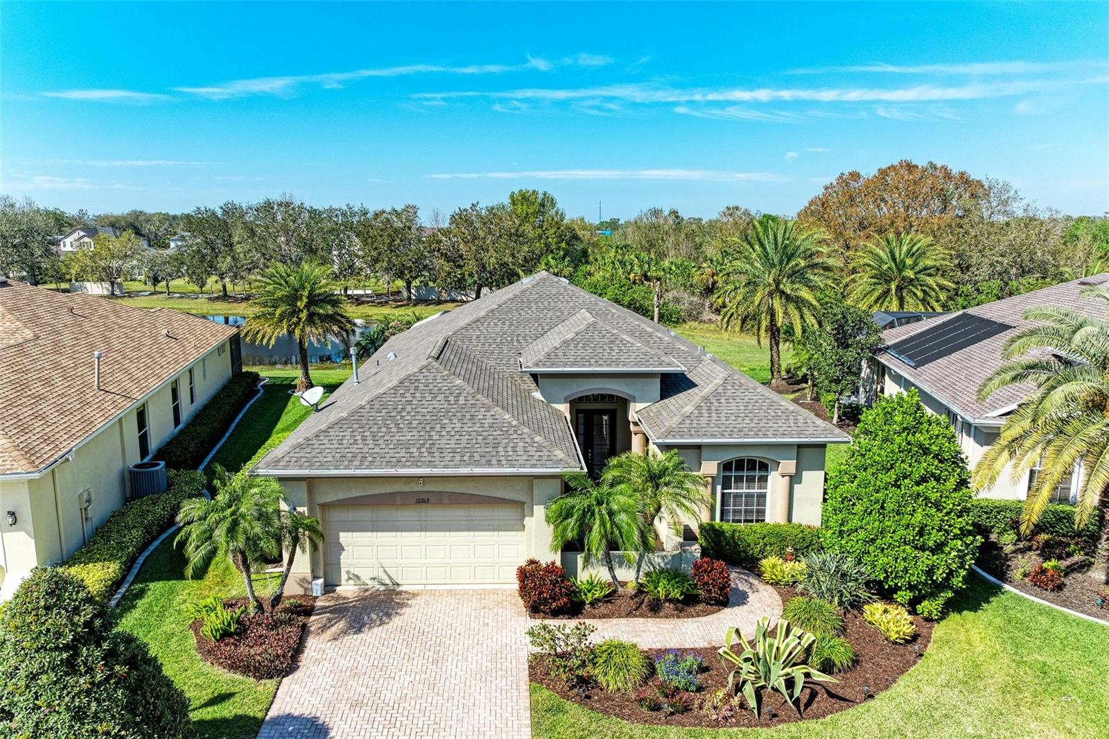 This beautiful Greyhawk landing home is loaded with upgrades & features that are sure to please even the pickiest of buyers! The paver driveway and gorgeous landscaping lead to the front courtyard and this is just the beginning. As you enter through glass door, you are greeted by an open concept split floor plan with high ceilings, crown molding and lots of natural light. The kitchen has been designed with the person who loves to cook in mind, featuring Zodiaq countertops, energy efficient stainless appliances, 36” maple cabinets and built-in wall oven and microwave and gas cook top and a large aquarium window that allow for a fantastic view. The owner's suite is exactly that you have been looking for. It features wood look tile flooring a well-equipped ensuite bath with dual vanities, Zodiaq counters, garden tub and separate walk-in shower. The two additional bedrooms have wood look tile flooring as well, and one has a murphy bed and they share the 2nd bath. Exterior of home is matched in style with the interior and provides great space for entertaining. The spacious outdoor area has room for an outdoor kitchen, and dining and conversation area. The PEBBLE TECH POOL has a calming water feature against the backdrop of the lake and picturesque green preserve. Seasonal weather changes make the hot tub an exceptionally exciting amenity and is bound to give you many hours of pleasure. A NEW ROOF was installed in April 2021! Greyhawk Landing is surrounded by the lush natural beauty of preserved woodlands and pristine lakes. Proximity to Lakewood Ranch, with easy access to both Tampa and Sarasota International airports, I75, UTC Mall, dining, entertainment, pristine world-renowned Gulf Beaches and Islands and boating on the Gulf Coast of Florida, championship level golf courses, recognized top schools and colleges. Community Amenities ($75 HOA Annual): 24-Hour Gated Community, Fitness Facility, Tennis, Pickleball, Basketball Courts, Playgrounds, Fishing, Baseball, Soccer Fields, Five-mile Biking and Walking Path, Two-Community Centers with Lagoon-style Pools, Spas and Waterslide. Enjoy an upscale, friendly Florida Lifestyle with an ideal floorplan. Make your appointment today before it's gone!