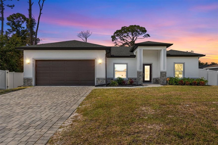 Discover refined modern living in this 2023 built three-bedroom, two-bath residence with a two-car garage, ideally positioned near Sumter Boulevard for quick access to I-75, shopping, and dining. Located not in a Flood Zone, so you get cheaper insurance all around! This home blends elegant design, energy efficiency, and quality craftsmanship including a fully fenced in backyard for privacy.

The home’s inviting exterior features natural stone accents, upgraded tropical landscaping, and a brick-paver driveway offering excellent curb appeal. Inside, the open layout is highlighted by soaring tray ceilings and elegant porcelain tile flooring throughout. Impact-rated windows and doors fill the home with natural light while ensuring lasting protection and efficiency.

At the heart of the home, the gourmet kitchen showcases premium granite countertops, 42-inch upper cabinets, and stainless-steel appliances. The spacious island provides ample seating, connecting seamlessly to the bright living and dining areas ideal for entertaining.

The primary suite is a serene retreat featuring two walk-in closets and a beautifully appointed en-suite bath with dual vanities, granite counters, and a walk-in shower finished with floor-to-ceiling tilework and Moen fixtures. A split-bedroom design ensures privacy, with two additional guest bedrooms and a modern full bath on the opposite side of the home.

Step through sliding glass doors to a covered lanai overlooking a large backyard ready for your dream outdoor space. Added benefits include a high-efficiency AC system, dimensional shingles, and an interior laundry room.
Located minutes from the North Port Aquatic Center, Heron Creek Golf & Country Club, and the scenic Myakka State Forest, residents can enjoy endless recreation from kayaking and biking to relaxing by the lazy river. Perfectly situated between Tampa and Fort Myers, this move-in-ready property offers the ideal balance of comfort, convenience, and contemporary style.