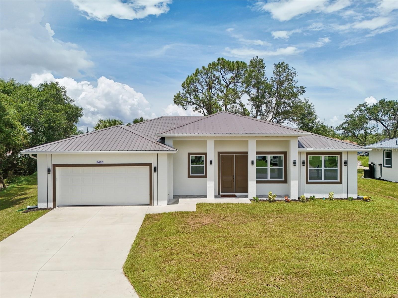 Brand new 2025 construction in a NO flood zone, move-in ready and packed with high-end features and energy-efficient upgrades. This Florida Green Building Coalition certified home offers lower insurance premiums and reduced monthly utility costs. Built to last with a durable metal roof, impact-resistant windows, doors, and garage door, plus tile flooring throughout including front and back porches. The interior showcases high ceilings with vaulted and coffered designs, LED lighting, remote-controlled ceiling fans, and a spacious laundry room. The chef’s kitchen features solid wood cabinets with soft-close drawers, granite countertops, and a garbage disposal. Sitting on an extended 12,000 sq ft lot with no HOA restrictions, this home offers space, freedom, and peace of mind. Comes complete with a full builder warranty and is ready for immediate occupancy. Don’t miss this opportunity to own a quality-built, storm-ready Florida home with luxury finishes and long-term savings.