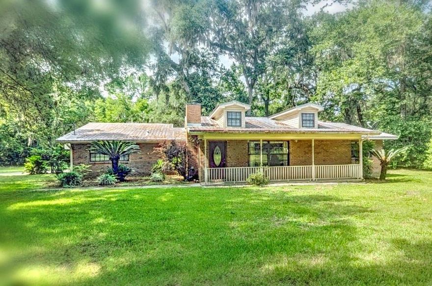 Back on market — home passed inspection and buyer had a last-minute change of heart.  Custom brick home on 3.16 acres in south Columbia County, just minutes from Lake City. Surrounded by mature trees and open yard space, this 3-bedroom, 2-bath home offers 2,473 square feet with a versatile layout that includes a front living room, spacious living and dining area open to the kitchen, and a separate flex room for a home office, den, or craft space. The kitchen features ample cabinetry and a large pantry, and the primary suite includes a walk-in closet and private bath. Enjoy vaulted ceilings, two wood-burning fireplaces, attic storage, and a screened porch overlooking the shaded backyard. Outside, the property offers a concrete floor garage/workshop with a bathroom, detached carport, storage shed, and plenty of space for parking, equipment, or projects. Metal roof, private well, septic system, paved county road access, and no HOA. Seller welcomes offers.