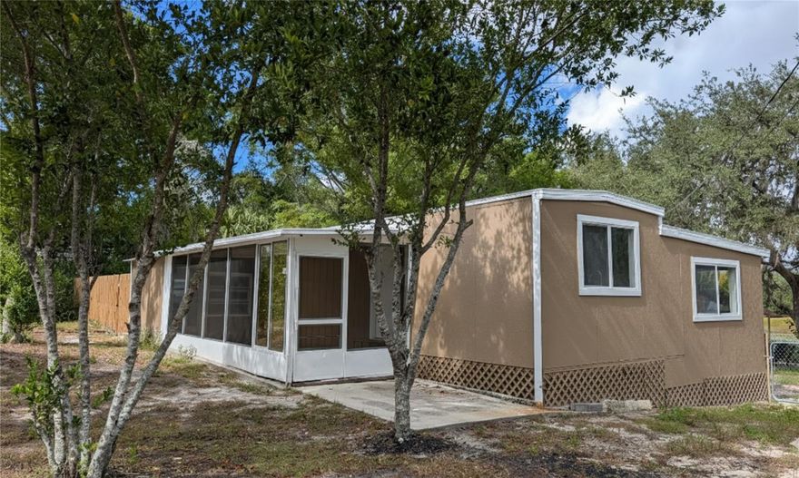 One or more photo(s) has been virtually staged. Completely renovated 3-bedroom, 1-bath manufactured home on an expansive 0.40-acre lakefront lot (approx. 15,250 SF) in Highland Lakes, Weeki Wachee. This extensively updated residence features vinyl plank flooring in the bedrooms, tile flooring throughout the remaining areas, soft-close cabinetry, granite countertops, and a fully remodeled bathroom with contemporary fixtures and an updated shower. The property also offers a new roof installed in February 2025, a well-water system, a septic system, is completely fenced, and includes a convenient 30-amp RV electrical outlet—ideal for RV parking and hookup. The functional floor plan includes a front Florida room/enclosed porch for additional living space, plus a spacious, tree-shaded backyard with exceptional privacy. Additional features include storage structures and a backyard gazebo with water and electricity—perfect for outdoor activities and entertaining. The true highlight is the serene lakefront setting at the rear of the property, offering peaceful natural scenery rarely found at this price point. Conveniently located in Hernando County with easy access to US-19, Cortez Blvd, shopping, dining, and Weeki Wachee Springs State Park. Enjoy Florida Nature Coast living with modern updates at an accessible price point.