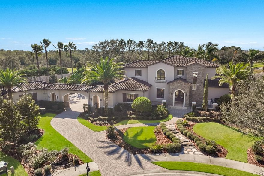 Welcome to a one-of-a-kind residence custom designed by renowned architect Francis Rodriguez and constructed by Nutter Construction. Nestled within the prestigious gated community of The Lake Club in Lakewood Ranch, this exceptional property offers unparalleled safety and security for those seeking a hurricane-free haven.

With 4 bedrooms, 3.5 bathrooms, 4 garage spaces, and an expansive 4,993 air-conditioned square feet, this home is a testament to both opulence and durability. Set upon an immaculately landscaped half-acre lot at the cul-de-sac's end, privacy reigns supreme in this exclusive sanctuary. Every detail was meticulously crafted to ensure pure quality and seclusion.

Prepare to be captivated by the luxurious experience that awaits you at the entrance. The charming stone embellished Porte-cochère and grand front entry, featuring cast iron double doors, provide a stately welcome. Step inside and marvel at the imported limestone flooring from Alicante, Spain. Every aspect of construction was carefully considered, with the highest grade impact windows, doors, and sliders chosen for maximum protection. Top-of-the-line Viking appliances adorn the gourmet kitchen, complementing the home's superior craftsmanship.

Elevated ceilings measuring 12 feet high, adorned with elegant wood beams in the formal living area and gathering room, evoke a grand yet inviting atmosphere throughout. The owner's suite, conveniently located on the lower level, boasts an en-suite bathroom with a stunning soaking tub, a spacious walk-in shower, and ample walk-in closets. For those seeking solace and tranquility, the suite opens to a private outdoor patio, an idyllic spot to savor a morning beverage, engage in meditation, or simply admire the breathtaking sunset.

On the upper level, an additional outdoor terrace treats you to panoramic views of the meticulously manicured grounds and the tranquil lake that surrounds the property. Step outside onto the screenless, west-facing pool patio, equipped with hurricane-grade automatic shades, and bask in the seamless blend of indoor and outdoor living. Entertain effortlessly with a fully-equipped outdoor kitchen and indulge in the modern pool with spa and waterfall, creating an oasis for relaxation and rejuvenation.

The ingenious floor plan of this custom home ensures a fluid and harmonious layout, flooded with natural light at every turn. As a resident of The Lake Club, you'll enjoy a resort-style living experience, with access to the Grande Clubhouse, two swimming pools, billiard and game rooms, tennis and pickleball courts, a fitness center, massage and skincare rooms, and a dining room featuring an in-house chef. Rest easy knowing that 24-hour guards provide around-the-clock security, allowing you to explore the community's trails, parks, and picturesque lakes without a care in the world.

If you are seeking a fortress-like home, meticulously designed for safety and constructed to endure, this property within The Lake Club is an extraordinary find. Embrace the opportunity to relocate away from Florida's storm-prone coast and create a life of tranquility and peace in this exceptional residence.