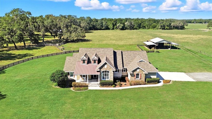 LOOK NO FURTHER -  10+-Acre - AG Zoning Country custom pool/spa estate with 2 Separate 4.5 acre fenced pastures + Pole Barn with electric & covered parking & storage *NO FLOOD ZONE* HI-SPEED INTERNET - HOME is designed for COMFORTABLE FLORIDA LIVING - NEW ROOF - CARRIER a/c Systems - POOL PUMP &  HEATED SPA - Beautifully and thoughtfully designed from the cultured exterior stone   exterior and throughout the lovely well-appointed living spaces... No quality detail has been spared - or views compromised.  This stunning custom home has so many architectural details such as arches, transom windows, cathedral and high ceilings -  large double-pane windows and triple sliding glass doors for easy access and views! Raised front porch as well as entertainment porch on the back with sauna, saltwater pool, heated spa and gas firepit, all screened enclosed, outdoor shower and easy access to 1/2 bath. Enter inside to beautiful views! Gorgeous wood-planked floors. Dramatic brick gas-heated fireplace in great room overlooking beautiful porch and pool/spa setting, as well as kitchen bar and separate dinette study-den with stunning wood built-in desk and bookshelves, high ceilings and dramatic transom window separate dining room has lovely views to front pasture. Abundant space for dining, display, storage and serving furnishings. A beautiful well-designed kitchen with gorgeous high-quality granite and solid wood custom cabinetry including display shelves, separate dinette and breakfast bar, quarry tile floors all stainless electric appliances, smooth gas top range, built-in oven, microwave, dishwasher and garbage disposal, separate bar sink in breakfast bar too. Loads of drawers and cabinets, separate walk-in pantry. Split bedroom plan with primary owner's suite has sliding doors to porch and pool, beautiful ceilings primary bath with two vanities and incredible walk-through shower, linen closet and huge walk-in closet. Second and third bedrooms are private with sizeable closets, including one walk-in. Oversize bath with two vanities and spacious all tiled shower, plenty of cabinet and drawer space. Oversize two-car separated garage with high ceilings, and workshop or gym area, and attic access too. Concrete, stone,  primary construction, high-speed internet, new roof, updated air conditioners, updated pool pump and heater, garbage disposal, metered sprinkler for flowerbeds, deep well, termite bond. Owner will consider owner financing, also separate addendum of personal property for purchase available. Only minutes to shopping, schools, restaurants, 20 minutes to the Villages for entertainment, dining and more. Enjoy equestrian events in Ocala with coastal pleasure only one hour away, theme parks too.