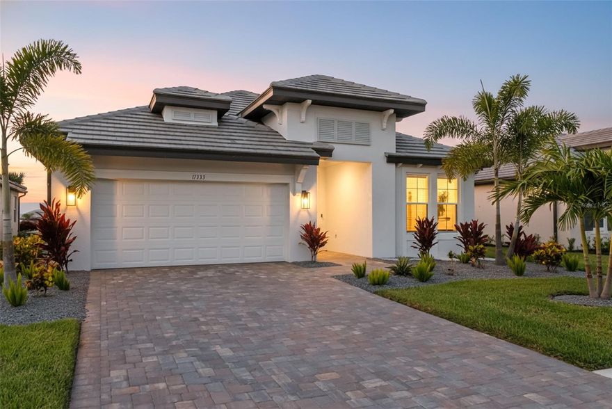 Experience refined Florida living in this exceptionally upgraded Calusa model by M/I Homes, perfectly situated on one of Sweetwater’s most desirable water front homesites. This 4-bedroom, 3-bath custom model quality home has over $117,000 in custom enhancements that elevate comfort and style! 
From its Sierra-style paver driveway and tropical landscaping to the sleek modern elevation, every detail exudes curb appeal. Impact-rated windows and sliders offer year-round peace of mind, no shutters required.
Inside, the gourmet kitchen is a showpiece with a waterfall-edge quartz island, herringbone tile backsplash, Sonoma-painted cabinetry with light rail, and GE Profile stainless gas appliances.
The owner’s suite provides a tranquil retreat featuring a spa-inspired bath with Cambria quartz counters, a frameless glass shower with matte black fixtures, and a custom-designed walk-in closet. An ensuite guest bedroom offers privacy and versatility, while also featuring a professionally installed custom closet.
Elegant details continue throughout the home including, luxury vinyl plank flooring,  8’ interior doors, crown molding in tray ceilings, upgraded matte black hardware,  lighting, tankless water heater, SmartShield structured wiring, and pre-plumbed outdoor kitchen rough in. 
Step outside to the expanded lanai, where peaceful water views set the stage for morning coffee or evening gatherings.
Located within the vibrant Sweetwater community of Lakewood Ranch, residents enjoy resort-style amenities, walking trails, and convenient access to top-rated schools, dining, and entertainment.