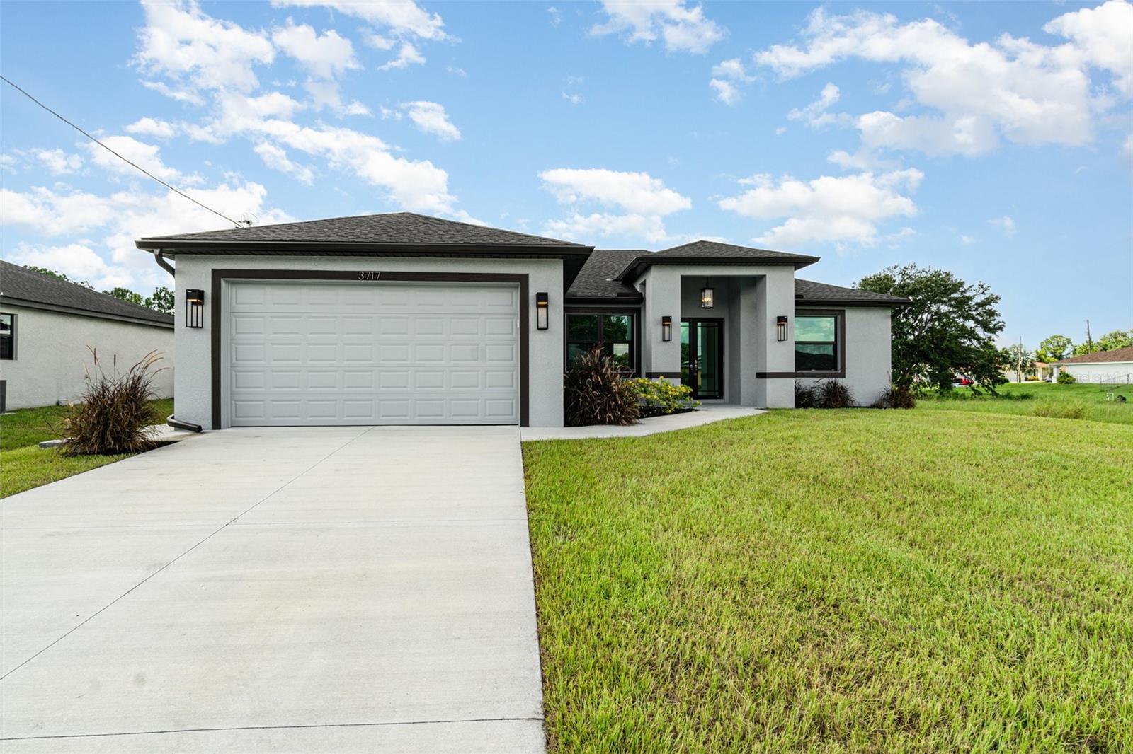Under Construction. Welcome to your dream home, a brand-new construction in a prime central location in Lehigh Acres that will be completed this FALL. This home offers a perfect mix of luxury, style, and convenience, built with exceptional quality and attention to detail. It's designed for modern living and peace of mind. This spacious 3-bedroom, 2-bathroom residence features a versatile den that's perfect for a home office or cozy reading nook. The split floor plan ensures privacy, with the luxurious primary suite tucked away on one side of the home. The primary suite is a true retreat, boasting an elegant tray ceiling and two spacious walk-in closets. In the spa-like primary bathroom, you can relax in a standalone soaking tub or enjoy the sleek, frameless shower. The bathroom also features two separate sinks and vanities, along with a private water closet. The heart of the home is the chef's kitchen, which features high-end GE brand stainless steel appliances, elegant quartz countertops, and soft-close cabinetry with a beautiful tiled backsplash. This space flows seamlessly into the large great room, making it ideal for entertaining. Throughout the home, you'll find 8-foot doors, decorative lighting and fans, and stunning large tile flooring. The living room also has a tray ceiling, adding an extra touch of sophistication. Beyond the stunning interior, you'll find top-of-the-line features for comfort and security. Hurricane impact windows and doors provide superior protection and energy efficiency. The exterior features a beautifully landscaped yard with lawn irrigation, which you can view from the screened-in lanai. The builder even added an integrated pest control system, allowing for easy access and a pest-free home. This fantastic location puts you close to everything you need. You're just a short drive from RSW International Airport, SR-82, and I-75, making travel a breeze. Enjoy the excitement of Spring Training for the Boston Red Sox and Minnesota Twins, or explore the area's excellent shopping and dining. When you're ready for a day in the sun, the beautiful Gulf Coast beaches are not far away. This home is more than just a place to live—it's a lifestyle. Come see what makes this brand-new home so special.