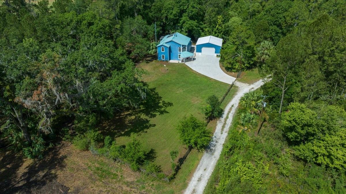 One or more photo(s) has been virtually staged. Price reduced on this move in ready home! Discover the best of both worlds in this beautifully updated one-owner home nestled on 5.42 acres zoned A1, perfect for animal lovers, hobby farmers, or anyone craving wide open space and privacy. Set at the end of a quiet drive and surrounded by towering mature trees, and a creek, this 3-bedroom, 2-bath retreat is a hidden gem designed for those who love the land but don’t want to sacrifice style or modern updates. Step inside to a light-filled layout where fresh neutral tones, custom picture windows, and quality updated finishes bring warmth and calm to every corner. The fully remodeled kitchen is the heart of the home, featuring granite countertops, new stainless steel appliances, a breakfast bar, and a charming eat-in nook. The spacious family room connects seamlessly to the formal dining room through French doors, making it ideal for special gatherings. The formal living room’s floor-to-ceiling brick fireplace adds rustic charm and comfort, while two updated guest bedrooms and a modern full bath offer space for visitors or family. Upstairs, the private primary suite is a true retreat with a brand new spa-like bathroom boasting dual vanities, a soaking tub, and a glass-enclosed dual shower. An office loft and private screened-in deck overlooking the woods make it easy to unwind and work remotely. A portion of the front acreage is fenced and there is a newly built 30x30 detached garage with electric that provides ample space for equipment, projects, or storage. Additional improvements include a 2014 solar-enhanced water heater, a 2025 water softener system, an annual termite bond, and a 2019 HVAC system. The durable metal roof, installed in 2014, ensures long-lasting protection and peace of mind. One-of-a-kind features like the handcrafted oak and ash staircase showcase the care and craftsmanship that make this home truly special. With agricultural zoning, this property offers endless possibilities for farming, livestock, or simply enjoying wide-open country living. The acreage extends all the way to Hwy 315, providing both convenience and opportunity for future use. Located just 15 minutes from Ocala and convenient to both I-75 and I-95, it’s an ideal home base for travelers, commuters, and equestrian lovers alike, especially with the World Equestrian Center close by. Survey and other supporting documents available, with no HOA.