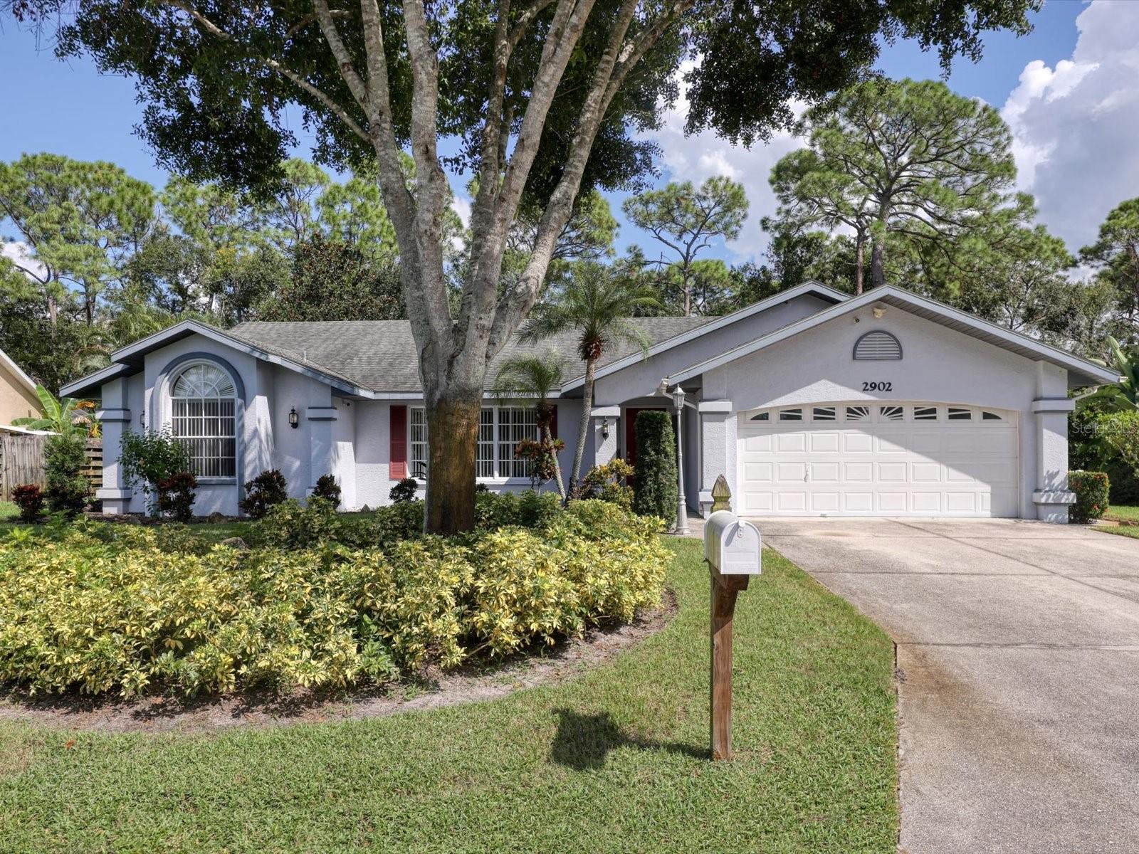 LOVINGLY CARED FOR HOME IN A QUIET NEIGHBORHOOD & SO MUCH HOUSE FOR THE PRICE! This inviting home offers a thoughtful layout with comfortable spaces for everyday living. Upon entry, you are welcomed by the expansive living and dining room combo, highlighted by a large picture window that frames the landscaped outdoors. The dining area opens directly to the lanai, creating a natural extension for gatherings and entertaining. The updated kitchen features granite countertops, overhead lighting, and a skylight that fills the room with natural light. It seamlessly connects to the spacious great room, where a wood-burning fireplace and garden views set the scene for cozy family time. Designed with privacy in mind, the split floor plan includes three bedrooms and two bathrooms. Each bedroom has a walk-in closet, while the guest bath conveniently opens to the lanai. The primary suite also has lanai access and features a large walk-in closet, double sinks, and a garden tub. Every room in the home overlooks the peaceful, landscaped yard. The lanai offers serene views of the private backyard and water, with plenty of space to add a pool. An attached shed provides extra storage. With the roof replaced in 2014 and HVAC in 2019, this home is ready for easy updates to compliment your personal taste to make it your own. Conveniently located near beaches, shopping, and entertainment. See why this community has become so popular and why this is the one!