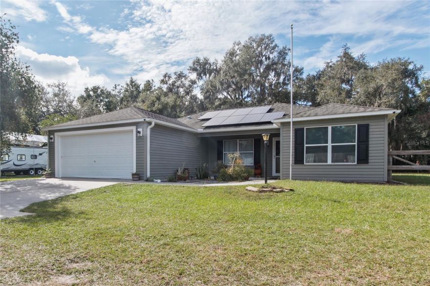 OWNED SOLAR + IMMEDIATE SAVINGS – SELLER PAID OFF SYSTEM AT CLOSING! Experience energy-efficient Florida living in this well-kept 2009 home featuring an owned 8.5 kW solar system (2023 & under warranty) valued around $40K.  Seller will pay off the solar in full, resulting in virtually no power bill beyond the standard $36/month utility service charge, plus enjoy the added value of owned solar  — immediate savings and equity for the buyer. The home offers 1,650 sq ft under A/C, including a 260 sq ft bonus room under heat and air from a reversible garage conversion. Open-concept living, dining, and kitchen areas feature vaulted ceilings and luxury vinyl plank flooring throughout, creating a spacious, modern feel with updated finishes. The living area’s 75” flat-screen TV with sound bar is included. Step outside to a 33' x 9' screened lanai, partially covered for year-round enjoyment, overlooking a fenced 0.7-acre flag lot set back from the road for a quieter, more private living environment with plenty of room for pets, play, or future additions. This property combines comfort, modern efficiency, and value — all within minutes of shopping, dining, and major roadways. Schedule your showing today and see how affordable Florida solar living can be!