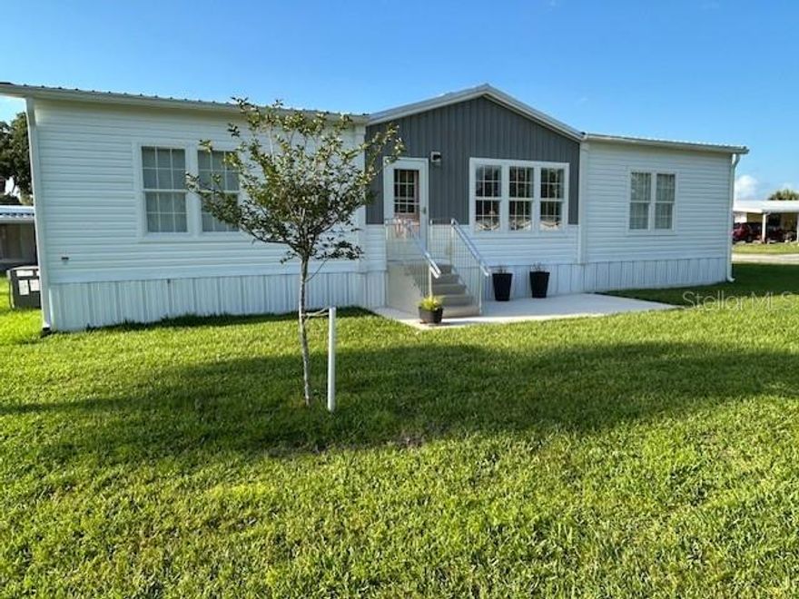 You have to see it t believe it! This custom-built Jacobson double-wide manufactured home offers 1,728 sq ft of comfortable living in an active 55+ community where you own your land. Featuring three bedrooms and two baths, the home boasts nine-foot ceilings with crown molding, ceiling fans in every room, and durable wood laminate flooring throughout. All 3 bedrooms have walk-in closets, while the spacious kitchen includes an island with storage and electrical outlets, a huge walk-in pantry plus all appliances.

Step outside to enjoy the custom carport with workshop storage, metal roofing on both structures, extra insulation, drywall walls, and heavy-duty hurricane tie-downs for peace of mind. A sprinkler system with dedicated well keeps the yard lush. Residents have access to a clubhouse with pool, pickleball, shuffleboard, fitness room, library, canal access to Lake June and Lake Carrie, plus boat and RV storage. Don’t miss this turnkey home in a resort-style community!