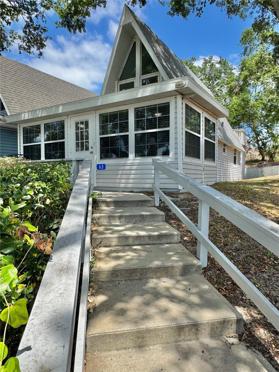 HILLTOP TOTALLY UPDATED A-FRAME Vacation Village home is now available for purchase. This is probably the largest, nicest one that’s been on the market in years! These 2/2 beautifully renovated units are not available often. This vacation lifestyle home has many updates like NEW ROOF 1 year ago, newer windows, tile floors whole bottom level, glass door,, TWO REMODELED Bathrooms, washer/dryer combo in primary bathroom and a beautiful remodeled kitchen. Sitting HILLTOP gets you a nice view and breeze on your front porch and your rear balcony porch. You can easily walk down to one of the many nearby community amenities, (the pool is across the parking lot from you). You’ll LOVE how It always feels like you're on vacation everyday here and it feels just like home too. Do you love how this home is set up? Most furnishing may be included in the purchase too! Not only does this community have an Olympic size swimming pool, tennis/pickleball/shuffleboard courts, basketball courts, car washing station, multiple playground areas it has CLERMONT CHAIN OF LAKES PRIVATE BEACH access via the community LAKEFRONT lot just for Vacation Village owners/guests, private community BOAT RAMP, Dock and even fenced in oversized parking lot area for RVs, vehicles and boats. Live here full time or part time, you can rent the unit long term or short term, you can even have the front office property managers handle the rental bookings for you and just send you the $$$$. Monthly HOA fees include exterior of structure such as the siding, roof, lawn, cable, WiFi, water, sewer, trash and common area amenities. You are minutes from anything you could possibly need from groceries, shopping, medical care, entertainment and dining. Orlando International Airport, Universal Studios and Walt Disney World® are less than 30mins away and the salty air/water/sand is 90mins away to many World Famous Beaches like Daytona Beach. What more could you ask for? Book your private tour and snag this one up fast!