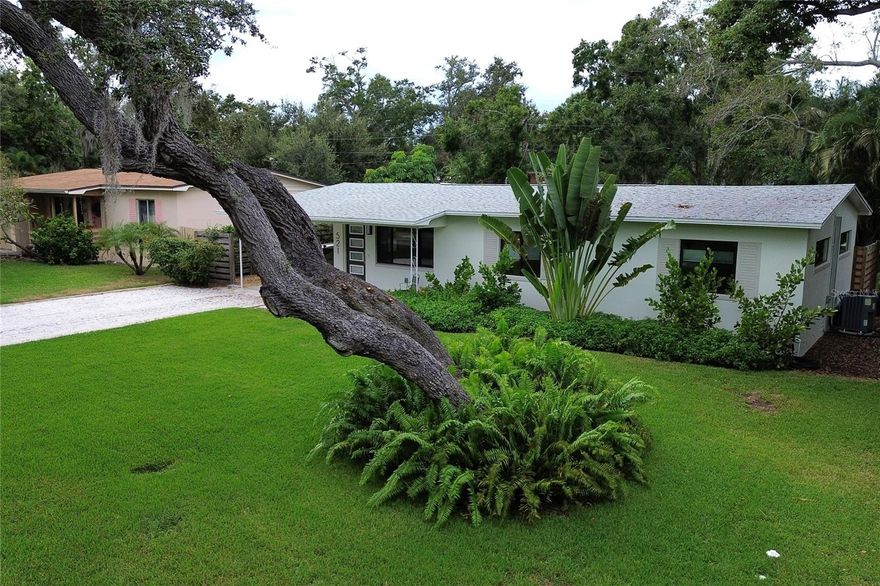 ABSOLUTELY STUNNING RENOVATION!  Top of the line in every way, this professionally remodeled mid-century home showcases refinished solid wood flooring, freshly painted interior and exterior, and solid wood doors throughout.  Every detail has been thoughtfully upgraded.  NEW FEATURES INCLUDE:  electric panel, large no-line Pella hurricane-impact windows with custom blinds, attic insulation, overhead lighting with dimmers, expanded kitchen with oversized island, bathrooms with oversized medicine cabinets and designer finishes, PVC plumbing throughout home, in addition to a stylish custom outdoor shower located outside the primary bedroom sliding doors.  The kitchen is a chef's dream with its spacious island, GE profile appliances, abundant cabinet space, and a lovely view of the backyard.  Sunlight illuminates the home during the day while window fixtures and dimmable switches compose private, soft-lit evenings.  Additional highlights include a 2019 roof, 2023 HVAC system, a new cement back porch, and a perfectly manicured and landscaping yard with a new irrigation system that collects from a reclaimed water well.  A serene bonus room offers the perfect flex space for a home office, music lounge, or creative studio - all with views of the lush backyard and majestic oak tree.  Move-in ready and designed for effortless single-level living, this home is an ideal fit for first-time buyers, downsizers, or anyone seeking a refined St. Petersburg lifestyle with every modern convenience already in place!  Steps away from the bay yet NOT IN A FLOOD ZONE.  Minutes away from Boyd Hill Nature Preserve and Lake Maggiore, Lassing Park and the vibrant arts and dining scene of downtown St. Pete, this home perfectly captures the essence of relaxed Florida living.