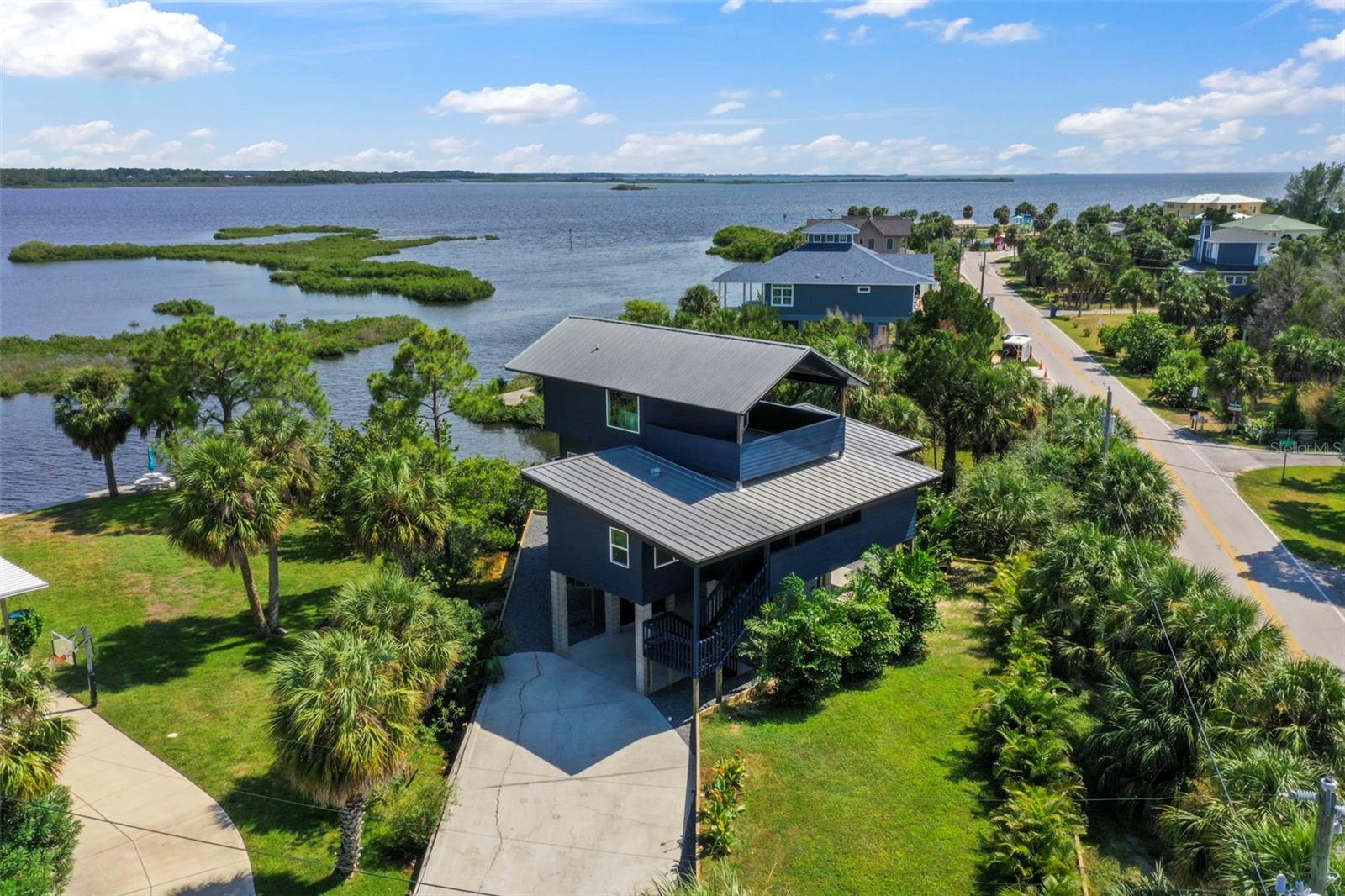 Welcome to your dream coastal retreat on Pine Island in Weeki Wachee, where every sunrise and sunset paints the sky in vibrant hues and you have water views from every room! This stunning 3-bedroom, 2-bath home has been transformed into a luxurious haven with top-notch coastal modern finishes that blend elegance and comfort. Imagine driving up to your oasis, parking under your elevated home, and relaxing in a charming seating area with serene water views. Your private paradise features a brand-new sea wall with steps leading to your secluded beach and direct gulf access—perfect for your boat or launching a kayak. The home itself is a masterpiece, with new hardie siding painted in deep blue that complements the shimmering waters. Expansive balconies with new composite decking and sleek cable railings offer perfect vantage points for savoring the breathtaking surroundings. Inside, the open-concept design showcases picture windows and wall-to-wall sliders framing spectacular water views. The kitchen is a chef's delight, with custom cabinetry, exotic level 5 natural stone countertops, a custom designer backsplash, and state-of-the-art GE café series appliances. Every detail, from custom light fixtures to the chic bar area, has been thoughtfully crafted to create a functional and beautiful space. Luxurious LVP flooring flows throughout, while smooth level 5 walls enhance the coastal vibe. The guest bathroom, with custom tilework and designer fixtures, exudes sophistication. Each of the two main-floor bedrooms opens onto private balconies overlooking the water. Ascend to the top floor, where the primary suite awaits—an expansive sanctuary with vaulted ceilings and eastern and western views over the Gulf. New hurricane-impact windows and sliders flood the space with natural light. The master bath is a spa-like retreat with a spacious closet, separate tub and shower, and a private balcony overlooking the water, where you can enjoy your morning coffee or soak in the oversized tub with views of the moonlit sky. This one-of-a-kind property offers more than just a home; it’s a lifestyle. Nestled on Pine Island, you'll be surrounded by nature, with dolphins, manatees, and otters as your neighbors. A boat launch for small to mid-size boats is just steps from your door, and Weeki Wachee River State Park is only 5-10 minutes away. With no rental restrictions, this home also offers incredible potential as a luxury vacation rental. Make it your private getaway or an income-generating paradise. Take a leisurely walk or hop on your golf cart to Alfred McKethan Pine Island Park, a 3-acre Gulf-front oasis with a beach, playground, volleyball courts, and a concession stand. Pine Island is a charming community, 6 blocks long and 2 blocks wide, with only about 40 homes. The optional HOA ($40/year) grants access to a private community dock, boat ramp, and beach. Experience the magic of island living—your ultimate Florida escape awaits. Schedule your showing today and make your island dreams come to life!