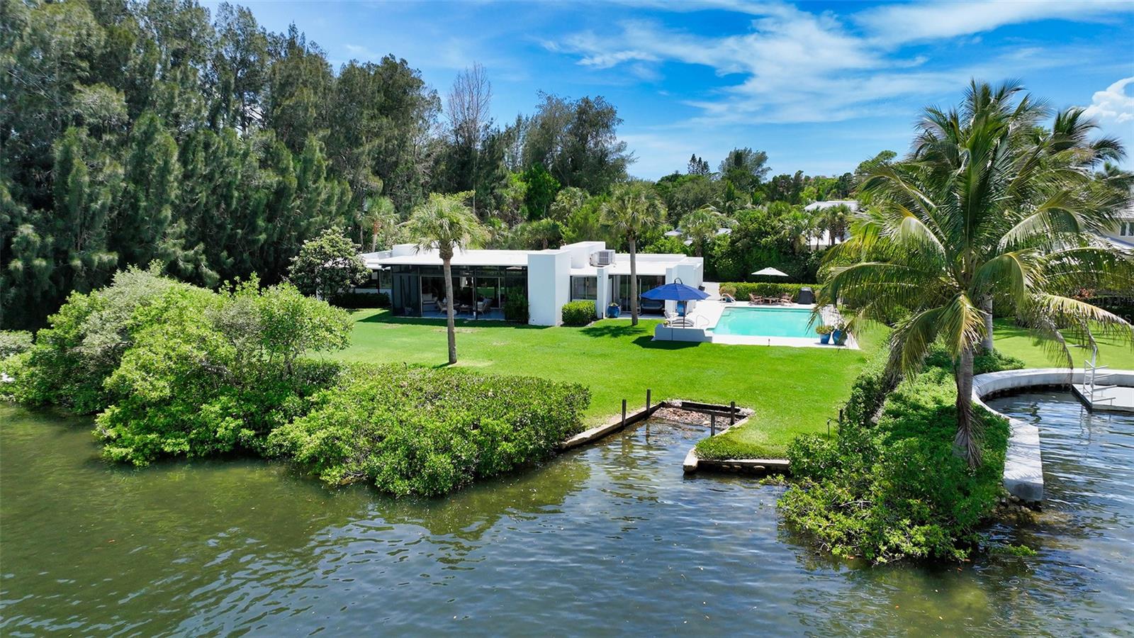 A rare Tim Siebert mid-century modern tucked away at the end of a peninsula on Casey Key. Nothing like it on the market. A jewel from the creative minds of the Sarasota School of Architecture. The property was selected for its privacy and location. Designed at a time when architecture was art, the home captures the beauty and peace of the surrounding environment. The home is strategically positioned on the lot to capture beautiful water views while taking advantage of the shade of the southern trees which keep the home cool during the mid-day sun. You'll marvel at the amount of natural light and the wide water views from not only the great room with its 11 ft. ceilings but every room! This picturesque oversized lot (.6 acre) provides you with 155ft. of waterfront. Dolphins visit daily. Tastefully updated with consultation from Siebert Architects to protect and maintain the original architecture and classic mid-century modern living. Diamond polished terrazzo flooring, updated kitchen, baths, doors, landscaping, lighting, A/C units and more. Walkways and pool deck are also terrazzo. The oversized salt water pool provides plenty of room for any size family and entertaining. The home also has deeded beach access conveniently located directly opposite Sandspur Lane. If you're simply looking for the perfect lot on Casey Key, the location and privacy are hard to come by. This is island living at its finest.