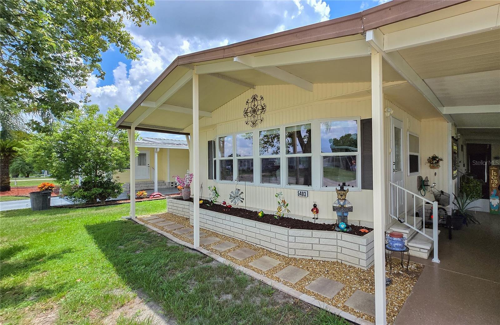 Welcome to Betmar acres a 55+ community where you own your land. Come see this spectacular Palm Harbor home which has been meticulously cared for. A few of the updates include New vapor barrier, a generator with electrical hook up, Roof lanai and carport have been hurricane reinforced. Enter into the front room which has a new door and new window. A spacious living room is connected to the dining area that has built in storage. The kitchen has newer appliances with lots of counter space and storage. Both bedrooms are in the back of the home and have been freshly painted. The hall bath has a spectacular WEST SHORE shower!
on the side of the home is the Florida room which has been tiled and rescreened. The laundry room is off the FL room with brand new washer and Dryer along with a slop sink and metal shelves. Outback you will find a fenced in yard with a lovely fire pit area, a great place to sit and relax in the evenings. A 10x12 metal shed for extra storage. A/C 2020, Metal roof. Extra mini split in the front of the home. Come see this one before its too late!! Come and enjoy Betmar and all the amenities to include Walking trails over bridges and ponds, 2 swimming pools, 2 hot tub, tennis, pickle ball, basketball, bocce, 27 holes of golf, shuffleboard, mini golf, billiards, game rooms, library, clubhouses, planned activities, Bingo and fun events.