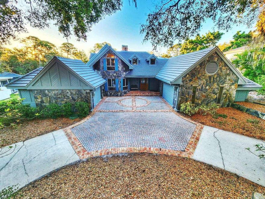 Welcome to this custom built executive residence with FULL SIZE IN-LAW SUITE on a conservation lot in North Pinellas County’s premier neighborhood, Cobb’s Landing on Lake Tarpon. This flexible home layout includes 4 bedrooms, 4 full bathrooms, 2 kitchens, 2 laundry rooms and a secondary private entrance for a completely private multi-generational living. Enjoy the distinctive architecture with soaring twenty-three foot ceilings in the main home featuring large cedar beams and fieldstone with a Triple Fireplace as a focal point. High and dry, no flood required. NEW CONCRETE TILE ROOF completed 2024 that includes a 10 year full warranty. The private primary suite offers French door access to the backyard and screened covered pool and hot tub. Large double head roman-shower, oversized double sinks, garden tub, water closet and expansive double closet area. Flexible and spacious living area has room for an office, game room and library. Dining area has wide views of pool and conservation woods. The main open kitchen includes tray ceiling, granite countertops, expansive island, a walk in pantry and expanded storage. Abundant natural light throughout the property. There is a full guest bathroom on the main floor. Upstairs has two large bedrooms, one with a fireplace, a bathroom with another roman shower and multiple closets. The In-Law side has a private entrance, an oversized one car garage, laundry room, pantry, living/dining room, en-suite bathroom, walk in closet and sitting room attached to the large bedroom. The separated oversized 2 car and 1 car garages provide space for multiple vehicles and additional storage in a loft/attic combination. Other amenities include intercom system, central vacuum, whole house water softener and charcoal filter. Indoor and outdoor living blend effortlessly with Anderson sliding patio and French doors leading to a covered entertainment area, including a large pool and hot tub. Enjoy nature’s beauty inside and out, including deer and other wildlife. Cobb’s Landing offers a marina, fishing dock, playground, basketball and tennis courts, sidewalks, parks, multiple neighborhood events and top rated schools. This home sits near some of the areas, most desirable destinations, including Innisbrook Golf Course, Tarpon Springs, Downtown Palm Harbor, Dunedin, and Gulf beaches. Enjoy an incredible selection of top-rated restaurants, shopping, and boutique experiences across all three vibrant communities, all just 30 minutes from Tampa International Airport. This meticulously maintained Palm Harbor home combines location, layout, and the beauty of nature - making it an exceptional opportunity in today’s market. All floor plans and dimensions are approximate. All square footage to be verified by buyer.