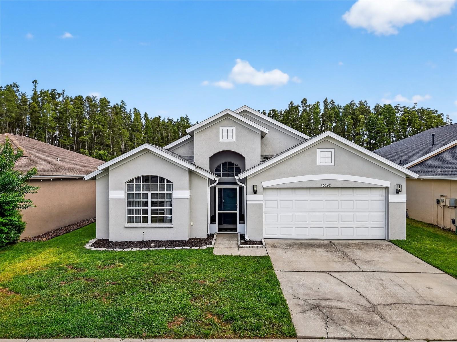 This beautifully updated 3-bedroom, 2-bathroom pool home is located in the highly sought-after Meadow Pointe community of Wesley Chapel. The home includes a 2021 roof, 2021 water heater, and 2021 re-screened lanai. Offering 1,952 square feet of living space, the home features an open and functional layout with high ceilings and modern finishes throughout, including a SMART thermostat. The interior boasts new wood-look luxury vinyl plank flooring, updated tile in the guest bathroom and laundry room, and all-new light fixtures and ceiling fans. The front of the home includes a welcoming living room, while the kitchen, dining, and family room flow together seamlessly, making it ideal for everyday living and entertaining. The kitchen has been fully updated with new quartz countertops, stylish backsplash, new hardware and fixtures, an island perfect for meal prep or casual dining, a coffee bar, and updated appliances that are Alexa-compatible. Large sliding glass doors in the family room, installed in 2023, allow for an abundance of natural light and lead to a screened-in lanai and private pool with spa, new gas pool heater, and peaceful pond and nature views. The spacious primary bedroom includes a large walk-in closet and a beautifully updated en-suite bathroom featuring a soaking tub, glass-enclosed shower, quartz-topped vanity, new mirror, modern light fixtures, and a private water closet. Two additional bedrooms are nicely sized and share an upgraded full bathroom. Enjoy the Florida lifestyle with a private pool and spa perfect for relaxing, grilling, or entertaining. Meadow Pointe offers resort-style amenities including a pool, splash pad, tennis courts, pickleball courts, basketball courts, clubhouse, and playground. Conveniently located less than 10 minutes to the Shops at Wiregrass, close to Tampa Premium Outlets, dining options, SR 56, I-75, and I-275. Zoned for top-rated schools and near Pasco-Hernando State College. This home is move-in ready and offers comfort, style, and convenience in one of Wesley Chapel’s most desirable communities.