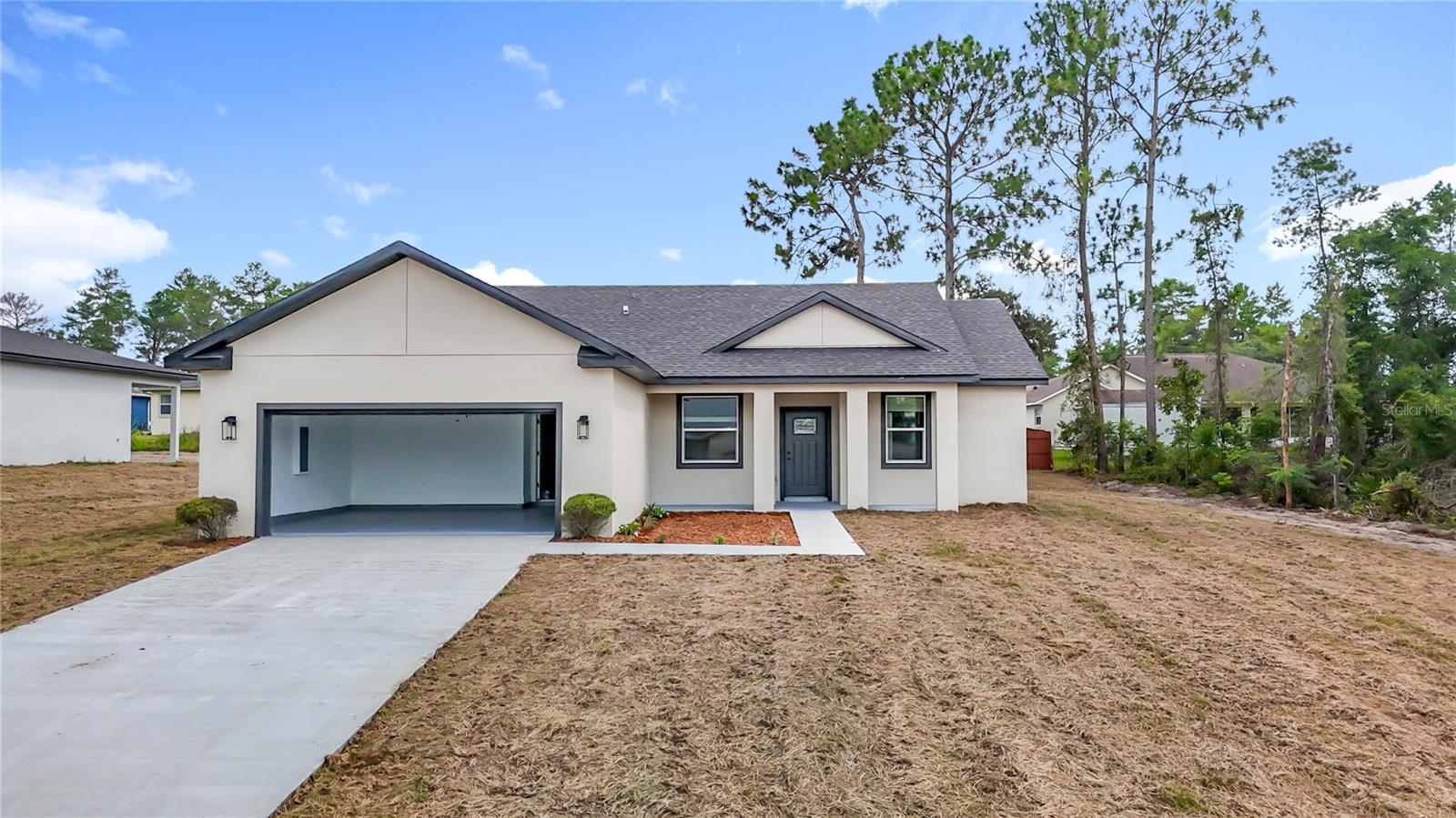 Under Construction. Welcome to your brand-new dream home in Ocala, Florida!
This beautifully crafted 4-bedroom, 2-bath residence offers the perfect blend of modern design and everyday functionality. Built with durable all-concrete block construction, the home features a spacious open-concept layout that seamlessly connects the living, dining, and kitchen areas—ideal for both entertaining and comfortable family living.The heart of the home is the gourmet kitchen, thoughtfully designed with luxury quartz countertops, premium cabinetry, and stainless steel appliances including a range, microwave, and built-in dishwasher. Whether hosting guests or enjoying a quiet evening in, this kitchen delivers both style and convenience.Enjoy modern light fixtures and ceiling fans throughout the home, enhancing comfort and adding a contemporary flair to every room.The primary suite is privately situated and features a luxurious ensuite bathroom with a double vanity, glass-enclosed shower, and a large walk-in closet. Three additional bedrooms are located near a full bath at the front of the home—perfect for family, guests, or a home office.A separate laundry room includes a built-in sink for added functionality. Step outside to a covered back porch complete with a built-in sink and hood—perfect for grilling and outdoor entertaining year-round.Conveniently located near schools, shopping, and major highways, this home offers both comfort and accessibility. Don’t miss your chance to own this move-in ready, modern gem in one of Ocala’s growing communities!