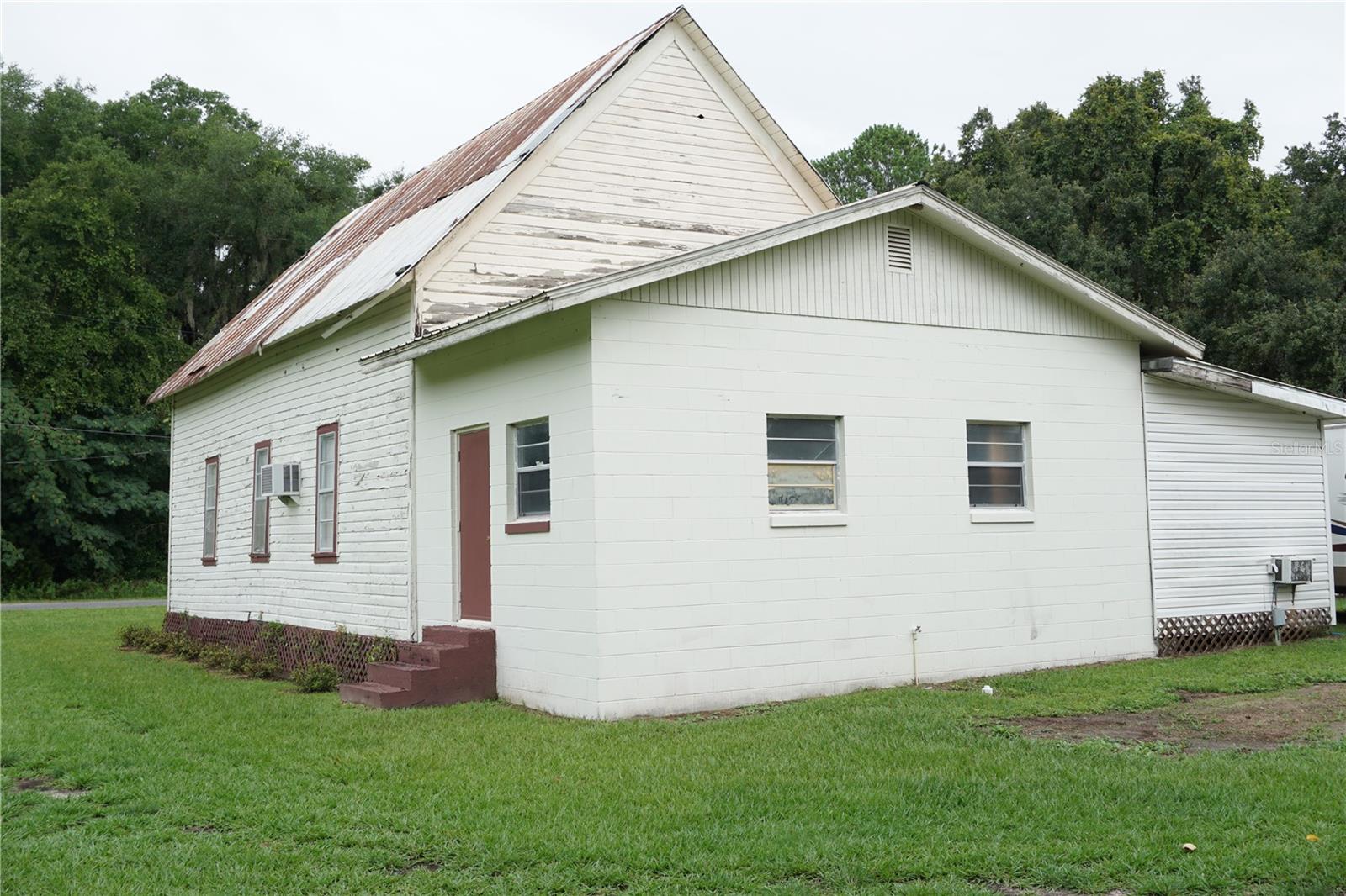 Multiple uses are possible with this 1514 square foot building on 1 acre of A1 property in Reddick. This could be a wedding venue and reception hall, place of worship, workshop and/or storage building. It may be possible to revamp it to be residential living space with the A1 zoning. There is a large auditorium, entry room, business office and two restrooms. The setting is on a paved country road with part of the land uncleared with trees and backs up to 7 acres for more privacy. There are two storage buildings on the property, an RV hook up, well and septic. There is a large modular trailer (office trailer) that is also for sale if interested ask for more info. Come explore the possibilities.