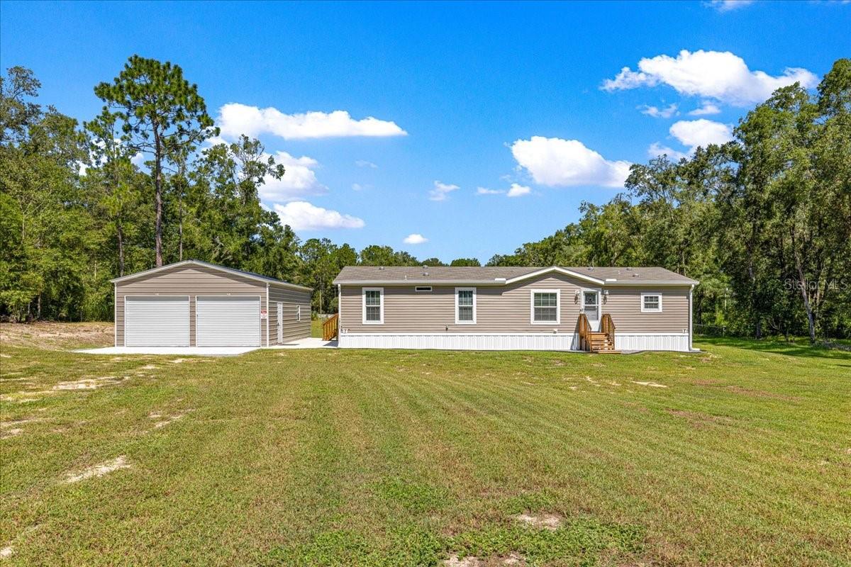 Built in 2024 this fully furnished home sits on 1.07 Acres with Steel Garage!
Welcome to this move-in ready 3-bedroom, 2-bath home, perfectly situated on 1.07 acres for space and privacy. Inside, you’ll find tongue-and-groove flooring, crown molding throughout, and vaulted ceilings that create a spacious, open feel. The living area features a custom electric fireplace with accent wall, while the kitchen offers a deluxe stainless steel appliances package, abundant cabinetry, and a large center island with seating. A dining area is tucked conveniently nearby for gatherings. The primary suite includes a walk-in closet and a bath with dual vanities, heated & lighted mirrors, and a beautifully tiled walk-in shower. Step outside through dual sliding doors onto a built-in covered deck, perfect for enjoying the peaceful surroundings.
Car enthusiasts, hobbyists, or anyone needing extra storage will love the 25x36 steel garage with concrete floor and full electric. The garage is equipped with cabinets, a steel shelf, a 60-gallon air compressor, and a 9500-watt generator. The additional shed includes 2 steel shelves and a seed spreader.
Additional highlights: 6 year transferrable home warranty, ceiling fans in all rooms, interior walls are all drywall, inside laundry room with washer and dryer included. R26 insulation, 16" on center floor joists, 7/16" OSB house wrap, deluxe front entry door with a storm door, gutters, power outlets on all corners of home, hose bibs on all corners of home, water treatment system and a Starlink system. Home is only 1/2 a mile from the paved road. No HOA, not in a flood zone and is A1/agriculture zoning. Call to schedule your private tour today!