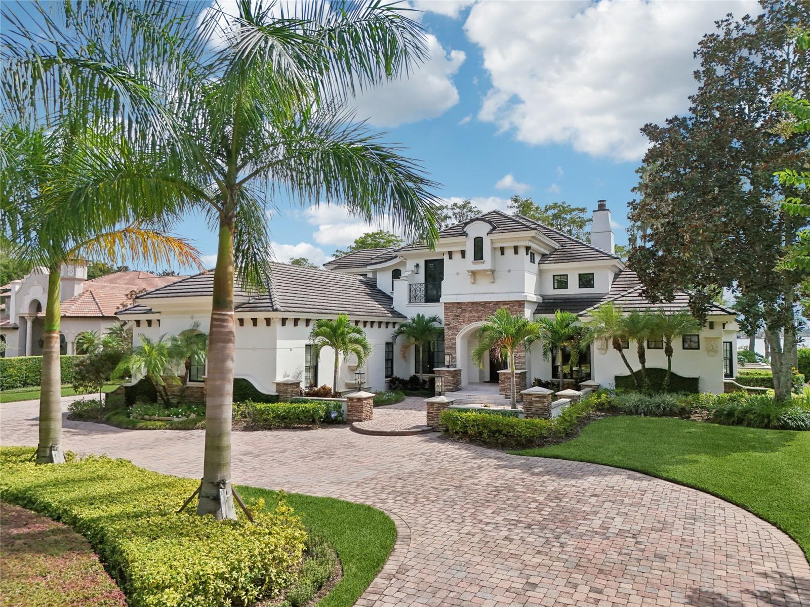 Experience the essence of luxury in this Magnificent French Country Lakefront Mansion, recently reimagined through a multi-million dollar renovation, setting a new benchmark for opulence. Nestled on the world-renowned Butler Chain of Lakes within the guard-gated private enclave of Isle of Osprey, this stunning property promises an unmatched standard of living.The residence boasts 5 spacious bedrooms and 5.5 bathrooms, sprawled across an over 1-acre lot with uninterrupted, breathtaking views of Lake Chase. Discover transitional luxury manifested through features such as 9' hand-forged Cantera front doors, premium stone and herringbone oak wood floors, custom 2-step crown and millwork, elegant double tray ceilings, and delightful hand-painted accents.Indulge in a gourmet experience in the brand-new kitchen, equipped with 42" Maple cabinets, polished quartzite countertops, custom island containing an additional Viking dishwasher, and a concealed walk-in pantry. This culinary space is now outfitted with top-of-the-line appliances from renowned brands such as Miele, Viking & Sub-Zero.Wine connoisseurs will appreciate the refurbished 500 bottle wine cellar, crafted with authentic Chicago Brick and featuring a recessed floor with a drain, ideal for winemaking.Enjoy the innovative design of wall-to-wall corner sliders that integrate outdoor living into the family room and kitchen, promoting a seamless flow of space. The Primary Suite is a tranquil haven that offers dazzling lake views, a serene sitting room, and a luxurious custom bath equipped with an oversize tub, dual vanities, a generous walk-in shower, and a spacious walk in custom closet.The expansive lower level hosts formal living and dining rooms, 2 cozy fireplaces, and a junior guest suite, providing its own private courtyard entrance for utmost privacy. The upper level features 3 en-suite bedrooms, each opening to a balcony. A state-of-the-art theater room now comes with a 100” screen, tiered seating, sound panels, and a convenient kitchenette.Step outside into the revitalized living area, complete with a full summer kitchen, a teak ceiling, a TV cabinet, a fireplace, and a heated spa and pool. Adding to the leisure options, the game lounge showcases a full bar area, wood floors, exquisite wainscoting, and a rich wood ceiling. Many upgrades such as newer AC units (4 total), two tankless water heaters, Moen Flow Smart leak detection system for the whole house. Experience the tranquility of lakefront living, while being just minutes away from Sand Lake's Restaurant row. This mansion perfectly marries grandeur and comfort, promising a lavish lifestyle unlike any other.