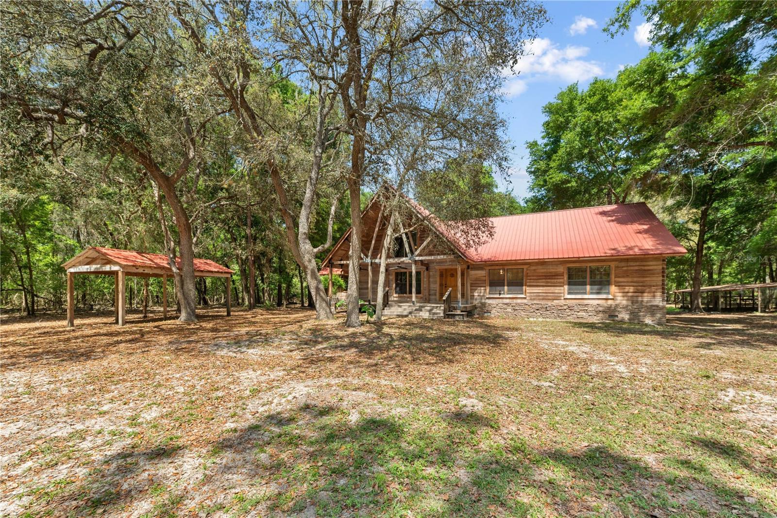 If you love Log Cabins then this is a Custom Log Cabin you have to see ASAP! This was built by the owner with so much Love and Care. This Custom Log Cabin has so much to offer and such unique features you just have to see it. There is 10.01 Acres that the LOG Cabin sits on with an auxiliary building just behind it that you could make into another living space for family or friends. The Log Cabin hosts three bedrooms 2.5 bathrooms with an open floor plan. There is this amazing staircase leading up to the bonus room with a half bath. The staircase railings are custom made by the owner. The large family room is attached with the open kitchen. The family room has a fireplace to sit around and relax on our few cold evenings we have in the winter. The kitchen hosts a large island, pantry, eat in area, lots of storage, custom cabinets, custom backsplash, custom flooring, two ovens, conventional oven, stove top, and much more. There is also an additional large laundry room that sits just off of the kitchen that could be used as a butlers pantry, office, or anything you would like it to be, it has a microwave with kitchen cabinets, sink & dishwasher. Heading out side to the back porch is a hot tub off the back large porch for entertaining. There is also a chicken coop or dog pen whatever you would like to use it for in the backyard. There is so much room to ride around on this 10 acres on your ATV's and have fun. Just down the street is the River and Boat Ramp to enjoy.