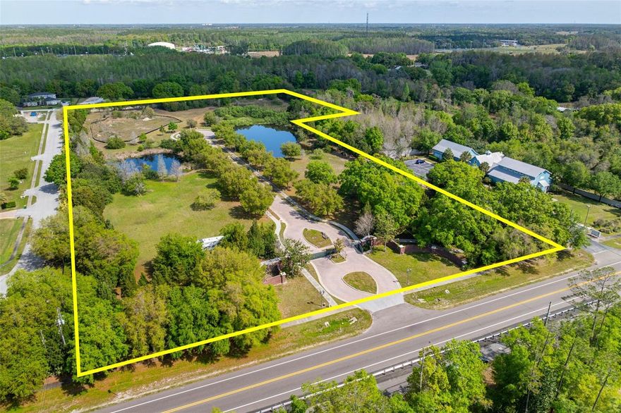 In the heart of this sought after East Lake area of Tarpon Springs, an opportunity redefines luxury and potential, presenting a canvas for your dreams on almost 9.5 acres of prime land. This unique offering, currently zoned as Institutional, could potentially transition back to its residential zoning. As you arrive, a gated brick entrance hints at the luxury and grandeur that lie within. The property is enclosed by an 8-foot concrete wall, ensuring privacy is paramount in this serene environment. The entrance road, paved in elegant bricks and lined with charming gas street lights, leads to a cul-de-sac, setting the vision for what can come. Manicured grounds are home to two tranquil ponds equipped with fountains, as you leisurely stroll along the property's sidewalks. If you decide to go the residential route, you can enjoy the freedom to create up to four homes on oversized lots or one magnificent estate compound, offering an architect’s dream to craft a legacy property for generations. All necessary utilities are readily available on-site, including electric meters, gas, high-speed internet/fiber, sewer, and water, plus three wells and a lift station, ensuring ease in bringing your vision to life. The property is surrounded by an approximately 1-mile long walking trail, offering a secluded nature escape, while the renowned Pinellas County Trail across the street encourages further exploration. Esteemed A-rated schools, prestigious golf clubs like Wentworth & Crescent Oaks, and nature preserves provide a backdrop for an enriched lifestyle. Horse trails and farms are closeby in the Keystone/Odessa area providing the best of both worlds, a quiet country living experience yet close to all. Upscale shopping, fine dining, and the vibrant downtown areas, including the infamous Tarpon Springs Sponge Docks and pristine Gulf Coast beaches, are all within a short drive, offering the best of Florida's lifestyle. This is not just land; it's a once-in-a-lifetime opportunity to create something spectacular, whether it’s a luxurious estate, a subdivided community of exclusive homes, or a private showroom. This piece of property can create a legacy to be proud of, schedule your private tour today!
