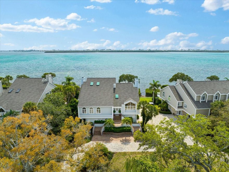 Situated directly on Sarasota Bay, with panoramic views of downtown Sarasota and Longboat Key this gorgeous property provides a rare opportunity to own one of the few unique free-standing homes in this coveted private coastal community. With its commanding presence and sweeping water views, this stately ONE OWNER 5,000+ square foot home is undeniably known as one of Tidy Island’s finest addresses. Considered one of Florida’s “hidden jewels” on the Gulf Coast, Tidy Island is a unique low-density enclave nestled amidst manicured grounds on 240 acres of preserve, natural shoreline, quiet roadways, resort-style amenities and 24/7 guard-GATED security. Refined luxury and timeless architectural detail exemplify this distinctive 3BD/3.5BH home brilliantly situated on a long circular drive leading to the grand double stair brick entry and a warm welcoming interior.  Awash with natural light and soaring ceilings the large Living and Dining rooms combine to provide a magnificent spot for entertaining family and friends with plenty of seating, gleaming oak flooring, elegant custom fireplace and enchanting bay views. The Living Room opens directly out to an expansive screened lanai creating a seamless indoor to outdoor transition, the essence of coastal Florida living. Adjacent to the Kitchen is a spacious casual dining area and comfortable Family Room with custom wood built-ins, a second fireplace, an exquisite wet bar, full bay views and access to a large waterfront patio with open air seating and the best spot for enjoying a spectacular sunset. The enviable Chef’s Kitchen has gorgeous custom cabinetry, a large center Island, granite counters and premium appliances including Sub-zero, Wolf, Miele and even a handy icemaker.  Located on the same floor, the large private Primary Suite offers a haven for rest and relaxation including the spa-like bath with double vanities, large shower, sunlit tub and separate water closet. The home’s private ELEVATOR provides service to all three levels, so ride up or take the stairs to the third floor where your guests will be more than delighted to stay! A dedicated space for a Home Office and Den is adjacent to a full bath and guest room and the sunny third bedroom has a full ensuite bath. On the ground level the home boasts an oversized three- car garage, loads of guest parking, a large storage and flex-space area for a shop or hobbies and a covered bayside brick patio. This one-of-a-kind residence delights and surprises at every level with its timeless appeal, tasteful upgrades and comfortable elegance. Located just minutes from the famous area beaches on Anna Maria Island and Longboat Key, Tidy Island also provides easy access to Tampa, St. Petersburg and Sarasota International Airports and all the cultural and community offerings imaginable! The PET FRIENDLY Community provides a maintenance-free lifestyle with on-site management, Clubhouse and gym area, two heated Pools and spas, tennis courts, kayak launch, walking trails and a Guard-gated secure entrance. The all-inclusive fee covers the amenities as well as well as group building insurance, grounds care, exterior maintenance, pest control, WI-FI, cable, water, trash and more. Tranquil, Exclusive, Secure. Come explore the lifestyle of your dreams.