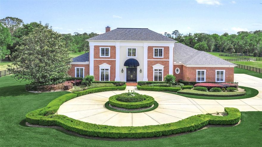 This remarkable property is a rare gem that you will not want to miss! Sitting on over 12 acres of high and dry land, this equine estate is located just a stone's throw away from the Winter Park/Oviedo city boarder. The property boasts a custom, 6,000+ SF home built by Charlie Clayton, along with a 2,000+ SF barn that offers 7 stalls and a separate tractor shed. As you approach the estate, you are greeted by a long Magnolia-lined driveway and a private pond with a fountain. The sprawling estate exudes peace and serenity and has been thoughtfully designed with the equine enthusiast in mind, with breathtaking views of the well-manicured & landscaped property and fenced pastures from almost every room. Enter to a soaring 2-story foyer with a wrap-around staircase, with an elegant living room on one side and private dining on the other. The open family room, kitchen, and dinette areas are lined with glass doors and massive windows, offering expansive views of the rolling greens beyond. The chef's kitchen is equipped with a large cooking island, double ovens, a 2nd prep sink, a wine refrigerator, and a walk-through pantry leading to the butler's prep area and laundry room with a 2nd refrigerator, sink, and dishwasher. The 5 bed/4.5 bath estate offers endless amenities throughout, like a whole home generator, hardwood floors throughout the 1st floor, and custom built-in shelves that retract and rotate for easy display of seasonal décor. The FIRST floor also includes a den/billiards room with a gas fireplace, a private guest suite with full bath plus an outdoor shower, and an oversized 3-car garage. Wake up to stunning views of the property from the downstairs Master Retreat, complete with an attached office, a spacious bathroom, and an enormous walk-in closet (13x16). The SECOND floor includes 3 additional bedrooms, 2 bathrooms, a 10 x 17 storage/mechanical room, and a bonus/media room with a wet bar and beverage refrigerator. Relax on the covered rear brick patio with phantom motorized screens or soak up the sun while fishing in the front pond. The circular front drive and side parking pad provide ample space for hosting friends and family. Only a few yards to the right is the 70x30 barn with its separate entrance driveway, ideal for large deliveries, horse trailer parking, and dumpster trash pickup. The barn is equipped with 7 stalls (including 3-10x20 stalls) all with custom doors and a couple featuring moveable stall grates, a tack/feed room, a wash stall, a large workshop/equipment room, a ½ bathroom, and a separate tractor shed building located behind the main stable. The property is connected to the County's water lines.  A complete irrigation system surrounds the main estate and runs from 2 wells along with the use of a septic system, the wells substantially save on the cost of water. However, the irrigation system also offers the option to switch a valve and connect to county water, depending on your needs. Backing up to conservation land, you'll enjoy the surrounding forest and privacy it provides, WITHOUT the cost of hefty HOA fees! While the home feels secluded, it is still only 1.5 miles from the 417 Expressway to Interstate-4, and only minutes from popular shops, stores, and restaurants (like Publix, Walmart, and Starbucks). Contact us today to receive a complete list of upgrades, as well as a floor plan and property survey. Room Feature: Linen Closet In Bath (Primary Bathroom).