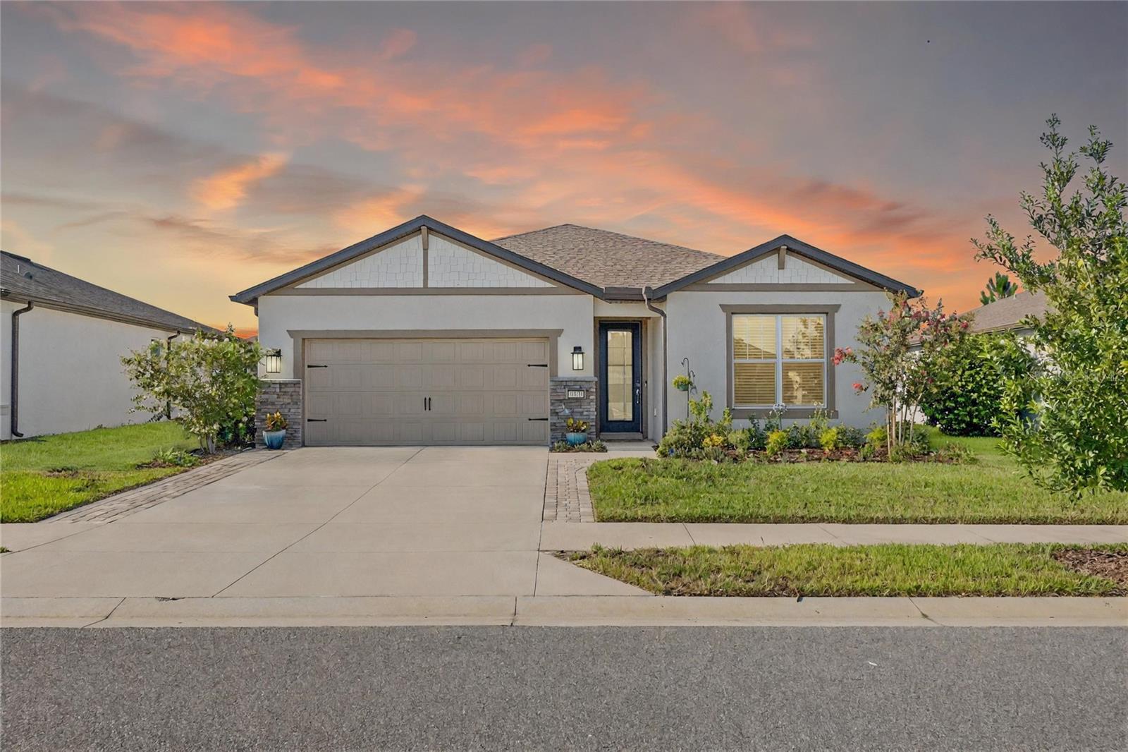 Discover the perfect blend of comfort and convenience in this beautifully maintained Cedar Model located in the sought-after community of Stone Creek by DEL WEBB. This home has three bedrooms, two bathrooms and an extended 2-car garage. Upon entering, you will be greeted by a stunning glass-front door, accompanied by high ceilings that create a warm and inviting atmosphere. The kitchen, complete with an island, stainless steel appliances, quartz countertops, a tile backsplash and a walk-in pantry, flows into the open living area. This layout is perfect for casual get-togethers and effortless entertaining. Bright sliding glass doors seamlessly connect the spacious living area to a delightful screened lanai offering serene views and year-round enjoyment. Beyond the screened lanai lies a paver patio measuring 6 feet by 15 feet. The primary suite features a ceiling fan and an en-suite bathroom with a tiled shower, including a bench, niche, and a frameless glass door, as well as a large walk-in closet. The second and third bedrooms have LED downlights. The guest bathroom has a walk-in tub and a vanity with a quartz countertop. This home offers ample space both inside and out for entertaining and unwinding. Other features include a water softener, a garage sink, epoxy flooring in the garage, and keyless garage entry. The driveway has a paver extension on each side. Take advantage of the various community features just a short walk away from the home. Experience low-maintenance, peaceful living tailored for your next chapter—schedule your private tour today and envision your future in this charming Ocala retreat.
