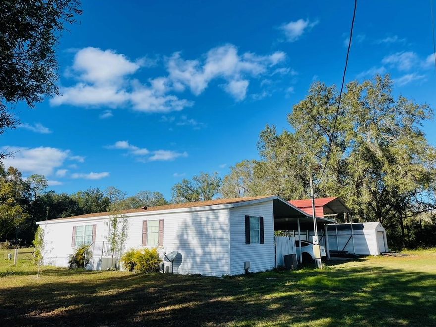 Here is a rare opportunity to own a turnkey, income-producing 6-acre property in the heart of booming Wesley Chapel. Perfect for investors, multi-generational living, or land bankers, this fully-fenced estate offers two leased residences have generated a combined $5,600 each month ($67,200 annually) in gross rental income, with additional subdivision potential already discussed with Pasco County. Preliminary meetings indicate the property could be divided into SIX 1+acre parcels, creating future development or resale opportunities. The main residence is a 1,574 sq ft 3-bedroom, 2-bath Jacobson manufactured home featuring a new roof, newer flooring, a large master suite with spa-like bath, a mudroom/laundry area, recent tile upgrades, and a brand new concrete patio replacing the previous deck. The guest house is a 1,650 sq ft 2-bedroom, 1.5-bath concrete block home with an updated kitchen and baths, newer roof and HVAC. Additional improvements on the property include a functional 3-stall barn (48x48) with 12x12 stalls, a concrete-floored feed/tack room, wash bay slab, run-in areas for horses and goats, multiple fenced pastures, and high-and-dry paddocks for rotating stock. A detached 3-car garage offers excellent space for vehicles, equipment, or workshop use, while a 17x30 storage shed and RV carport with slab provide additional utility. The property is gated, has two wells, and enjoys creek frontage at the rear. Located less than five minutes from I-75, this property provides the perfect blend of country privacy and convenience, central to Wesley Chapel’s shopping, dining, healthcare, and just 20 minutes to South Tampa or north to Brooksville. With this cap rate at this asking price, this is a truly unique offering for investors seeking cash flow, land value, and future development upside in one of Pasco County’s fastest-growing areas. Shown by appointment only – please do not disturb tenants.