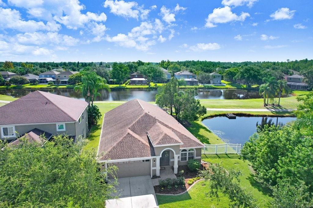 Experience Florida living at its finest in this stunning 3-bedroom, 2-bath home, perfectly situated in the highly sought-after gated Heritage Harbor Golf Community of Lutz. From the moment you arrive, you’ll be impressed by the combination of timeless design, thoughtful upgrades, and sweeping golf course and water views that make this property truly special. Inside, you’re greeted by beautiful wood-look porcelain tile floors that flow seamlessly through the main living areas, while warm wood laminate flooring adds comfort to each bedroom. Elegant plantation shutters frame the windows, inviting in natural light while offering privacy and style. The heart of the home is the chef-inspired kitchen, boasting striking leathered granite countertops, an expansive pantry with abundant cabinet storage, and a generous kitchen island perfect for gathering with family and friends. The open layout flows effortlessly into the family room and breakfast nook, creating a bright, welcoming space for entertaining. Just beyond, sliding glass doors open to an oversized screened lanai—the ideal spot to enjoy your morning coffee or evening glass of wine while overlooking the lush golf course and tranquil pond. The luxurious master suite is a private retreat, featuring a spacious sitting area, walk-in closet, and spa-like ensuite bath with a soaking tub, separate shower, dual granite-topped vanities, and porcelain tile flooring. Two additional bedrooms share a beautifully appointed second bath with double sinks, leathered granite counters, wood-look ceramic tile, and a tub/shower combo. Practical touches include a laundry room with utility sink and upper cabinets for extra storage, conveniently located just off the garage. Living in Heritage Harbor means more than just a beautiful home—it’s a lifestyle. Residents enjoy access to a championship golf course, clubhouse, resort-style pool, tennis and basketball courts, playground, and more. All of this is located close to top-rated schools, shopping, dining, and major commuter routes for easy access to Tampa, the beaches, and beyond. This is the home where comfort meets elegance, and every day feels like a getaway. Schedule your private showing today and discover all that this exceptional property has to offer! Roof (2015), HVAC (2017), Hotwater Tank (2015)